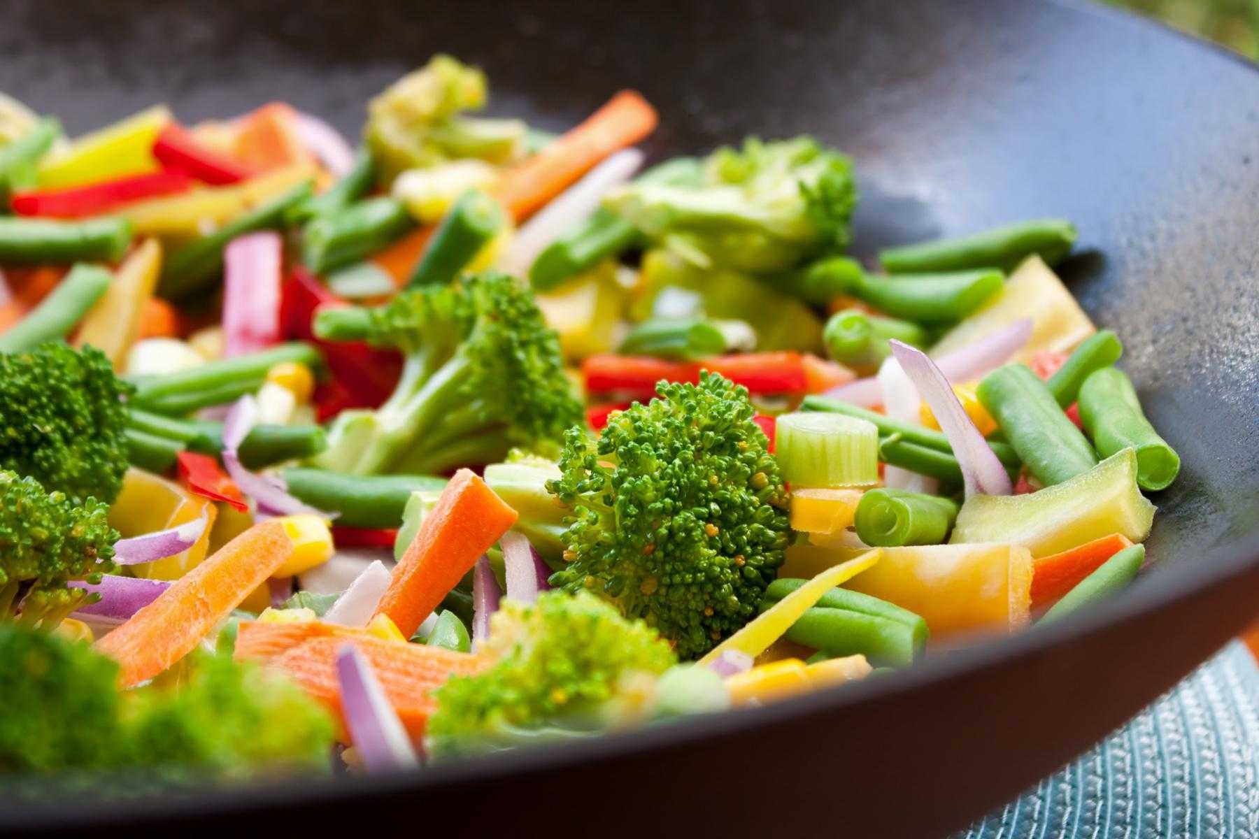 A close-up of a bowl of orange vegetable stir-fry.