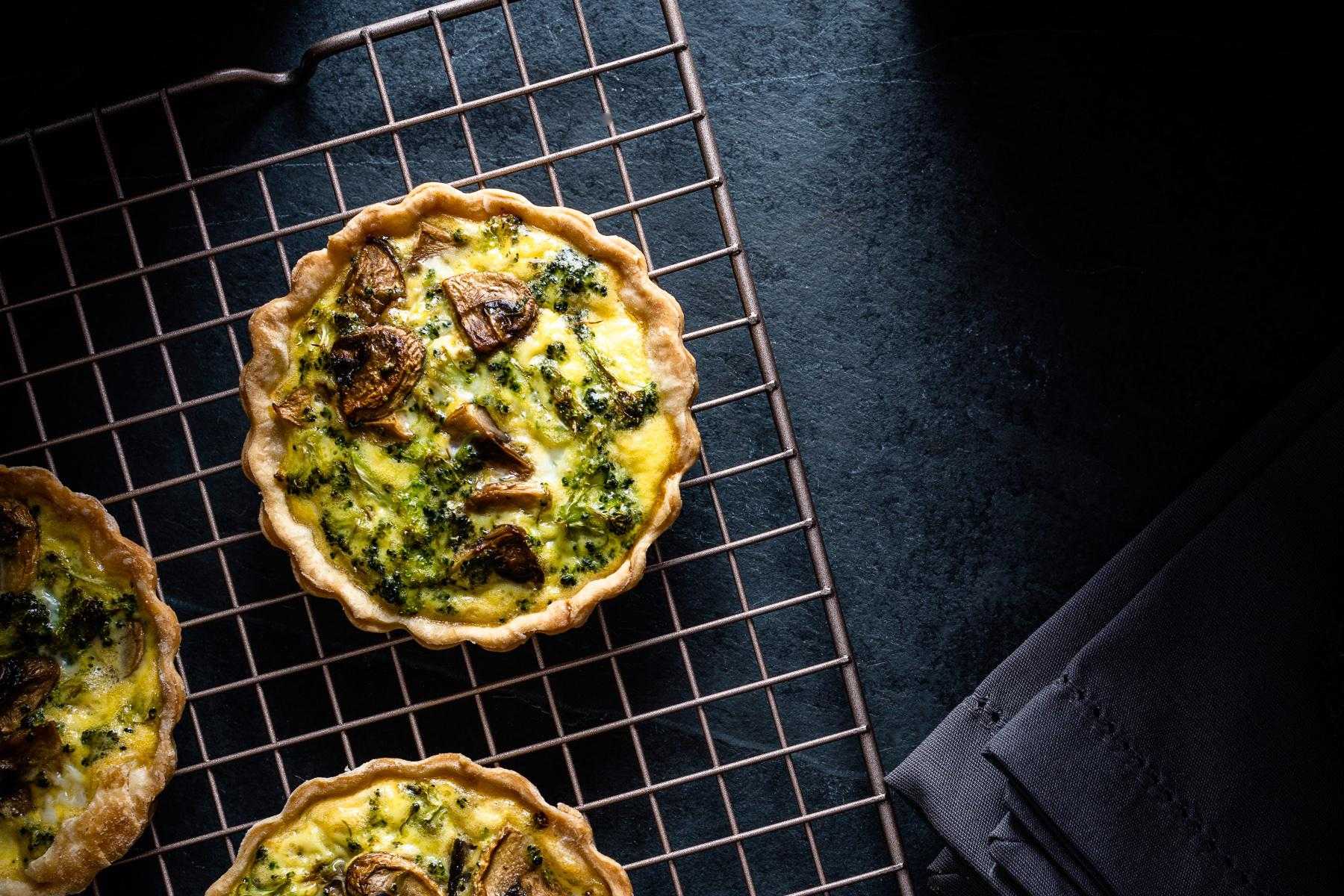 Wild mushroom and aged gouda tart on cooling rack.