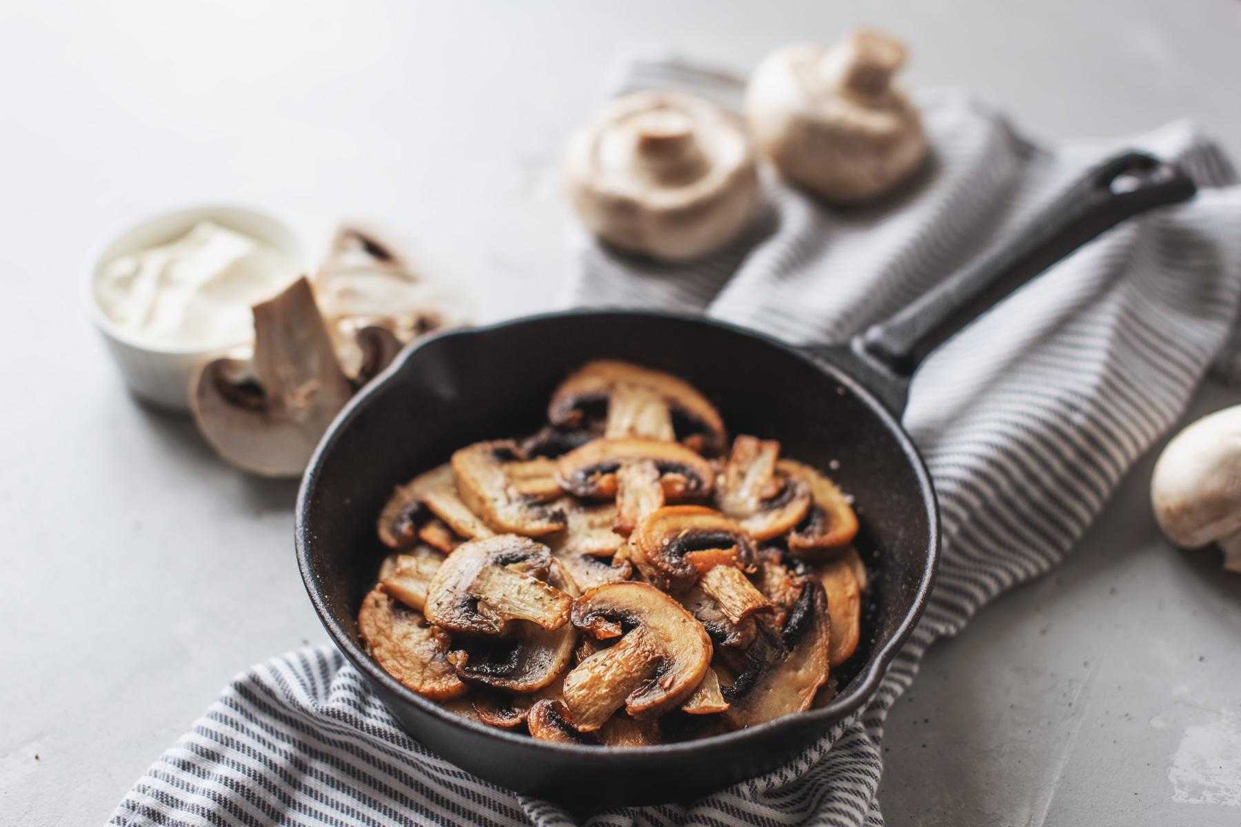 Overhead view of frying pan with chopped mushrooms.