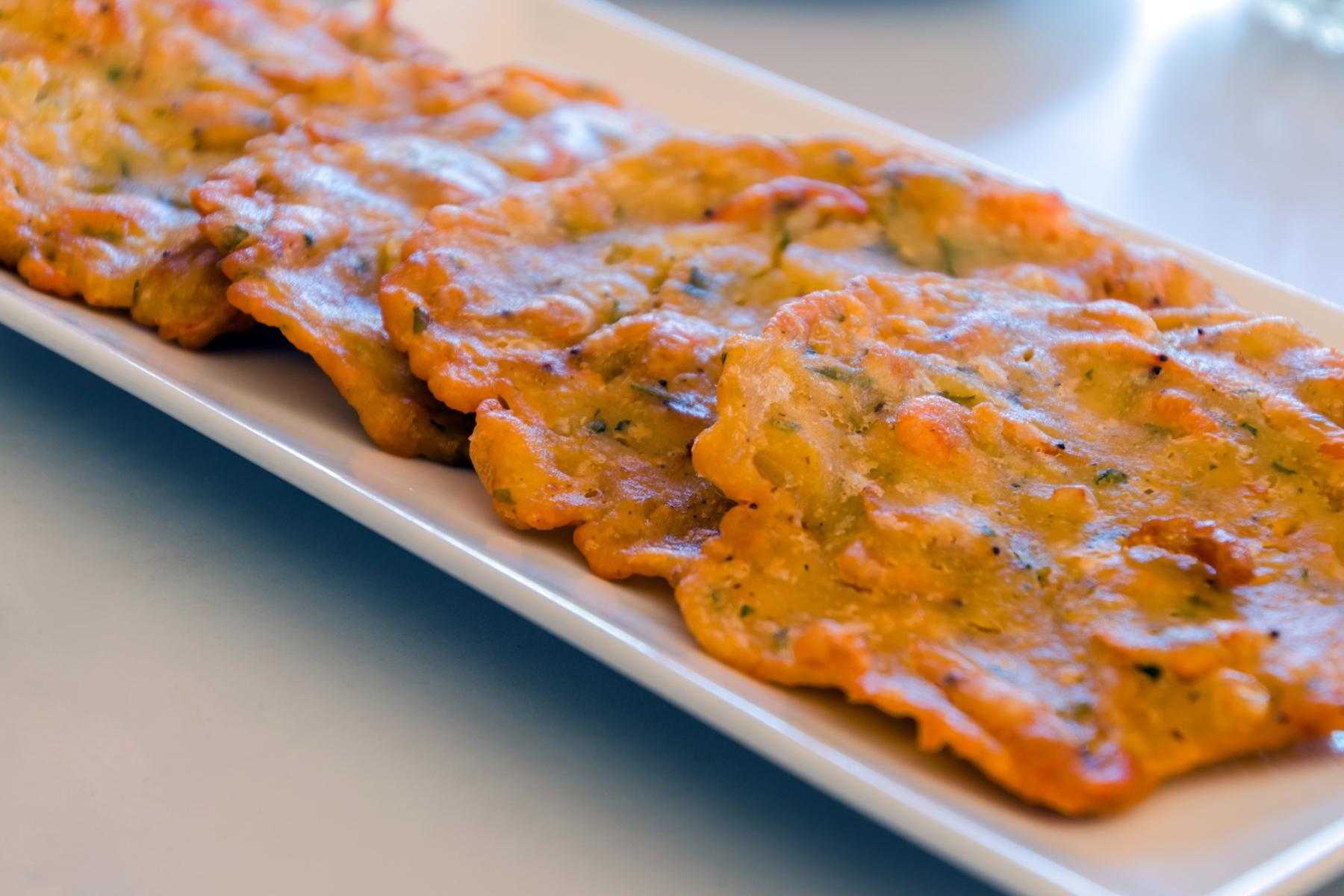 A plate of shrimp fritters with cucumber pineapple salad.
