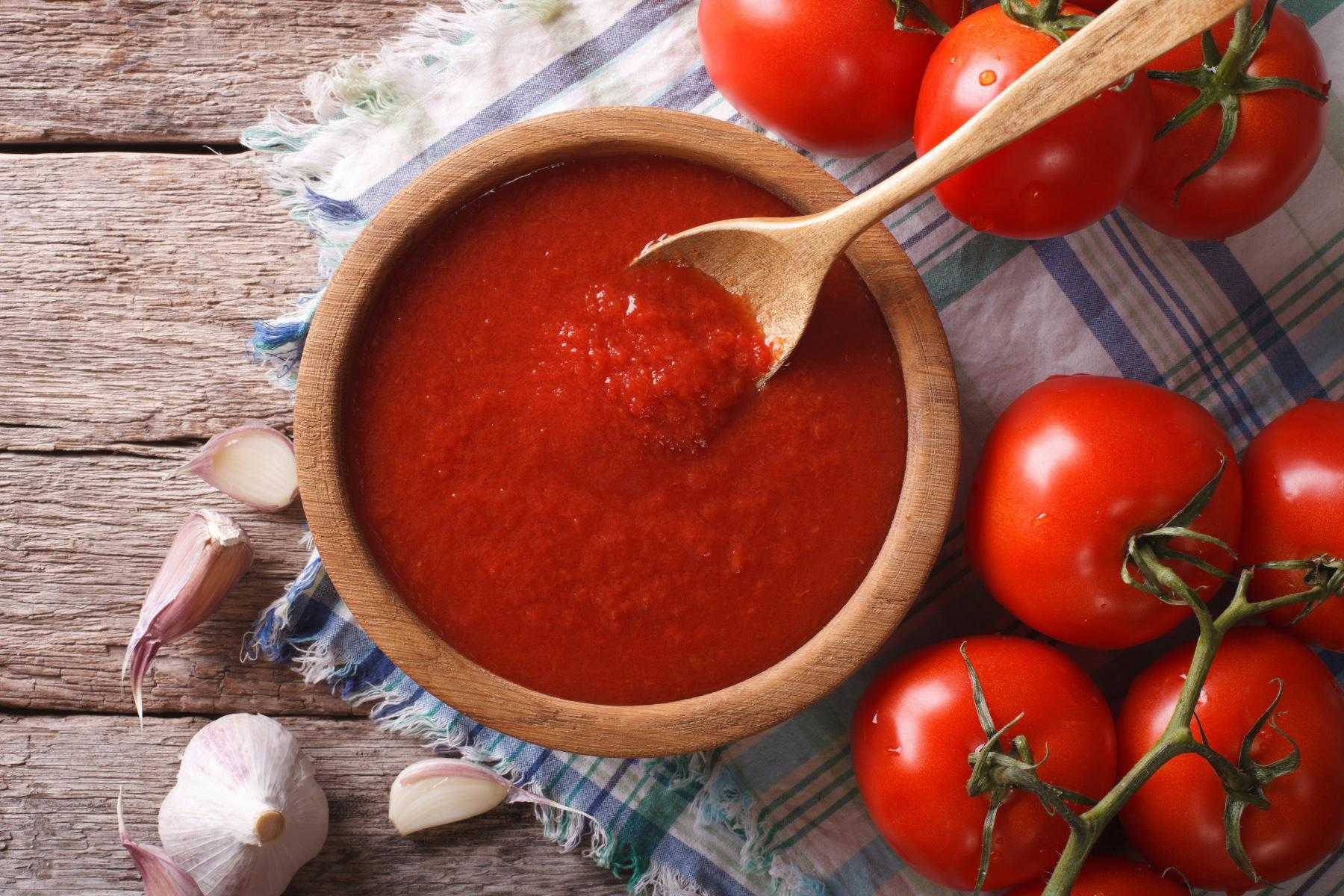 Overhead view of a wooden bowl of marinara sauce.