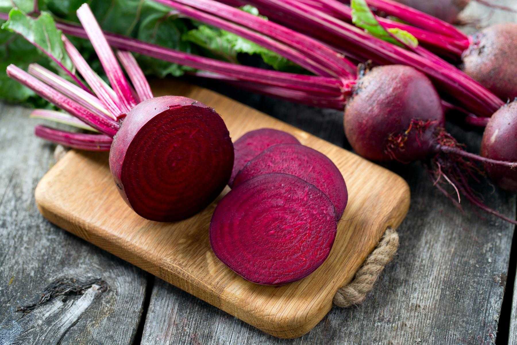 Sliced beets on wooden cutting board.
