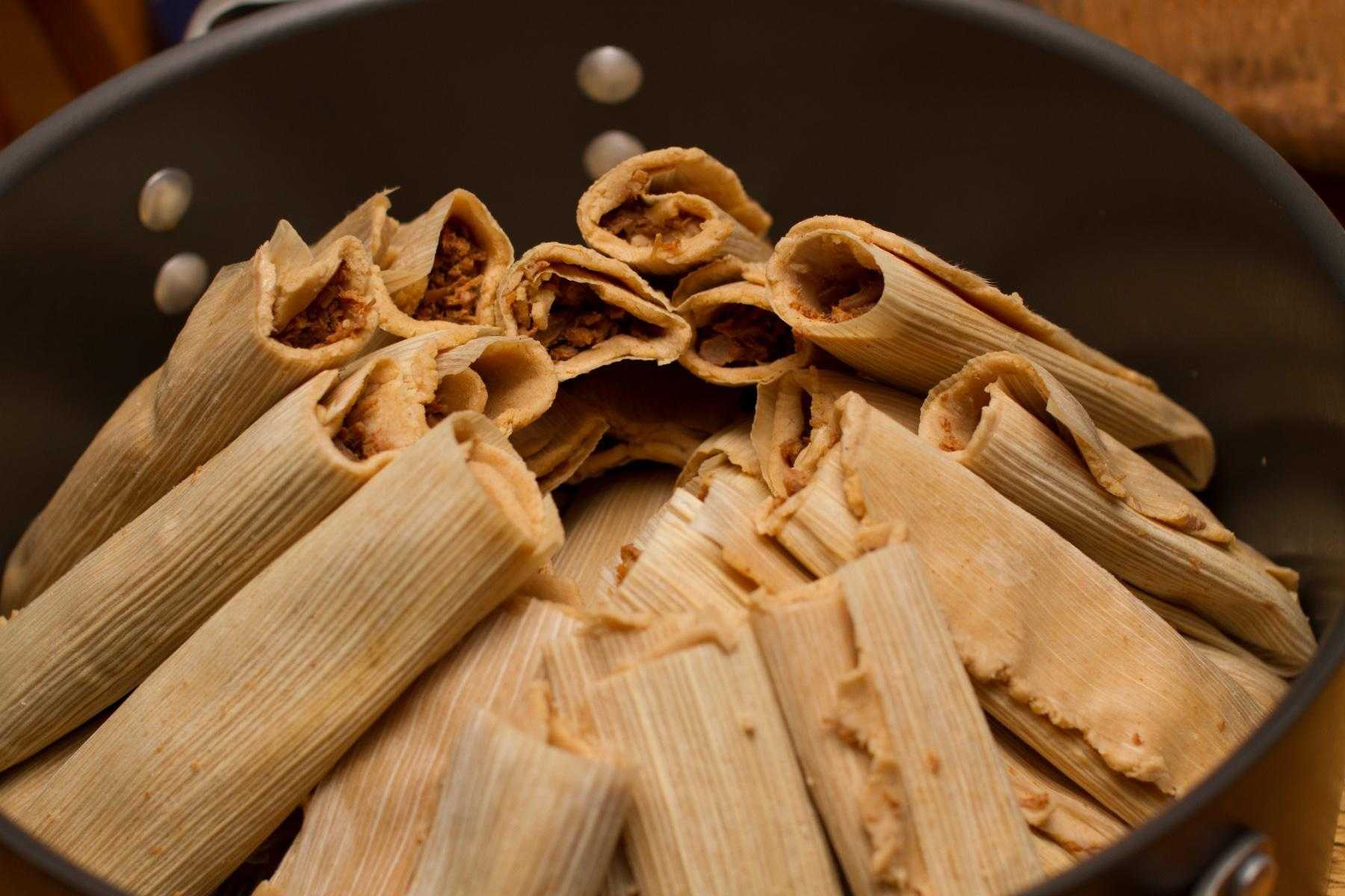 Tamales cooking in a pan.