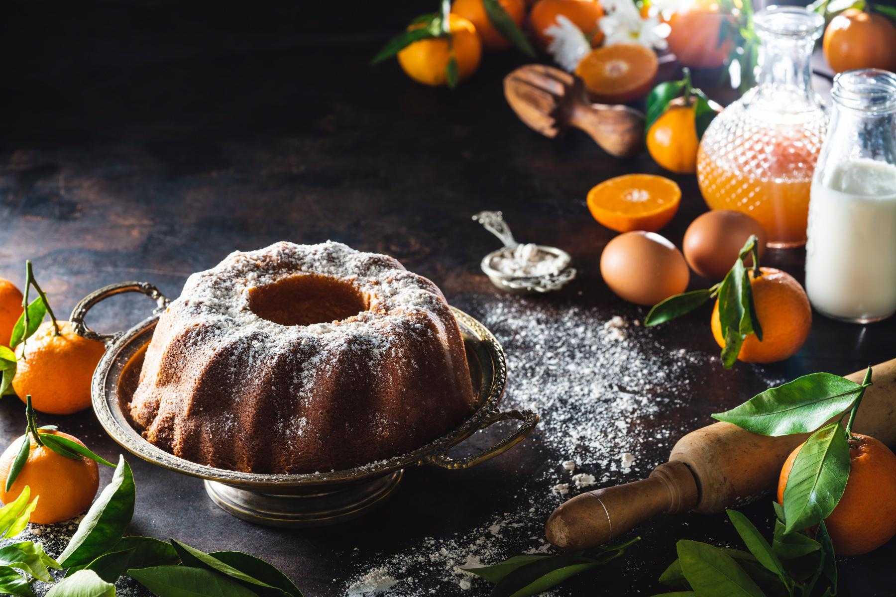 An orange pound cake with powdered sugar sprinkled on top.