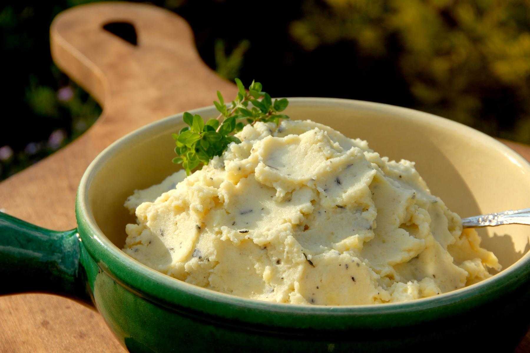 Close-up of a green bowl of mashed potatoes.