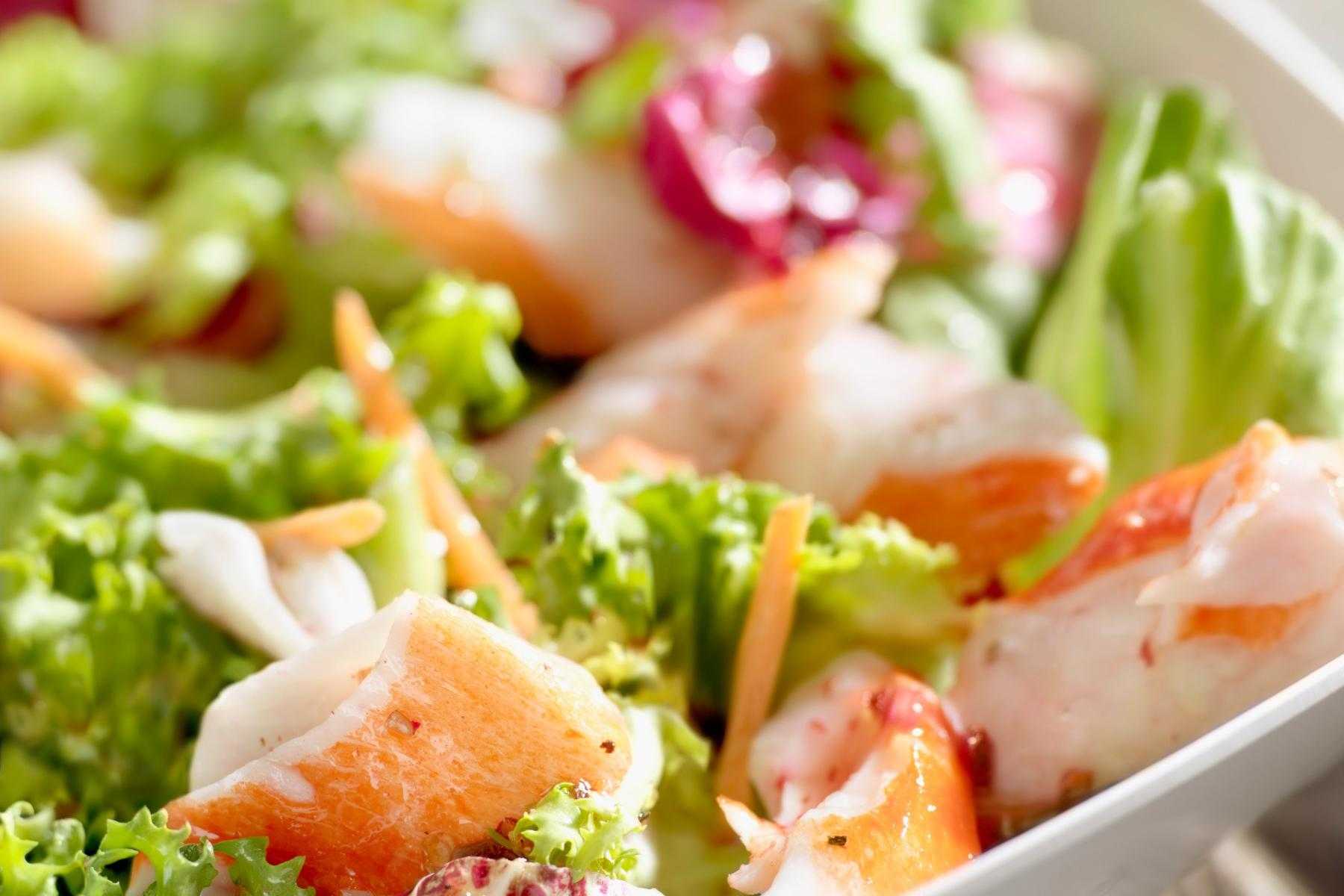 A close-up of a jicama slaw salad with orange crab.
