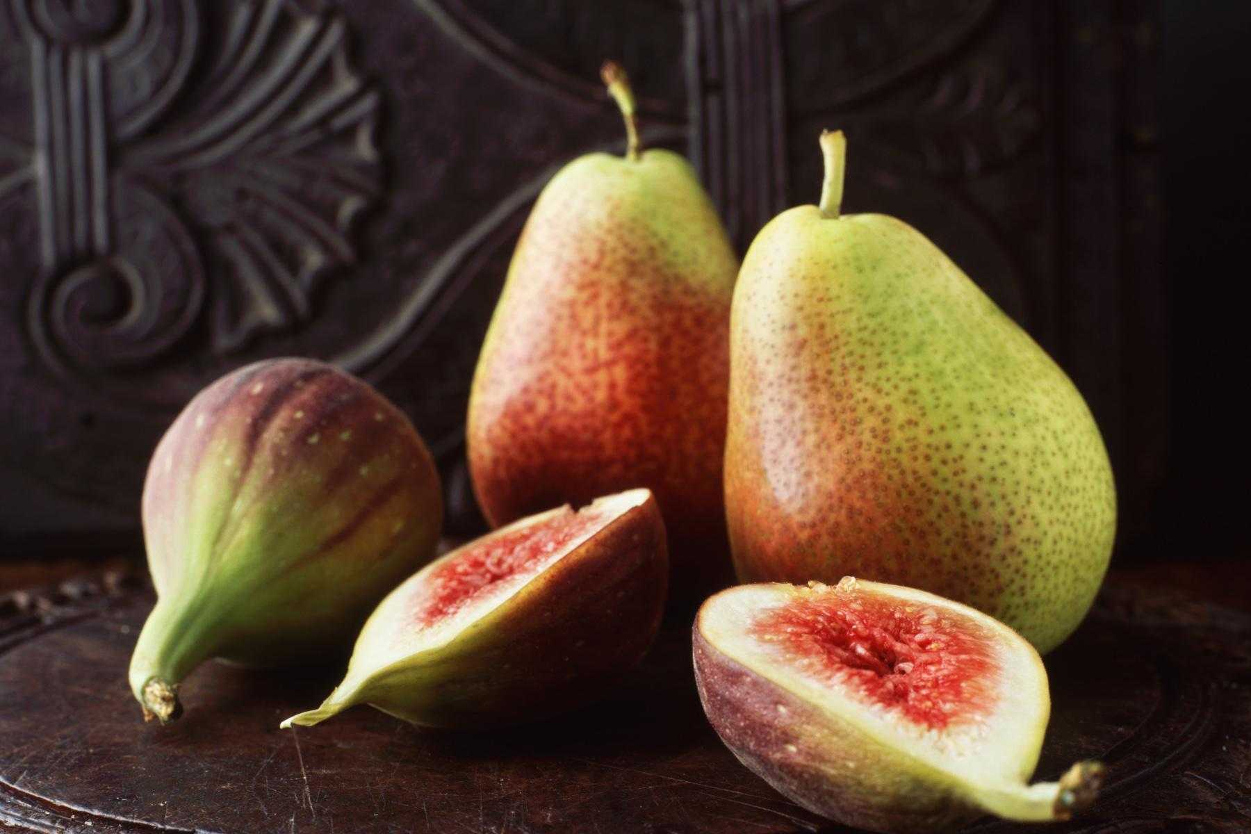 Close-up of pears and figs against dark background.