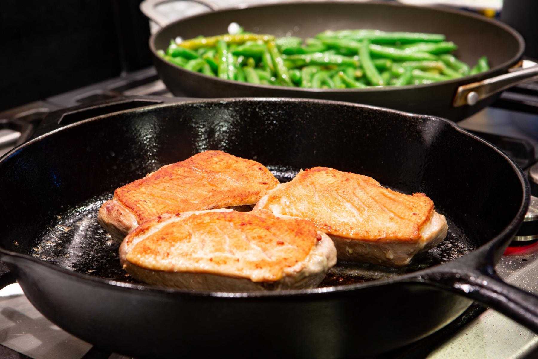 Duck searing in cast iron pan.