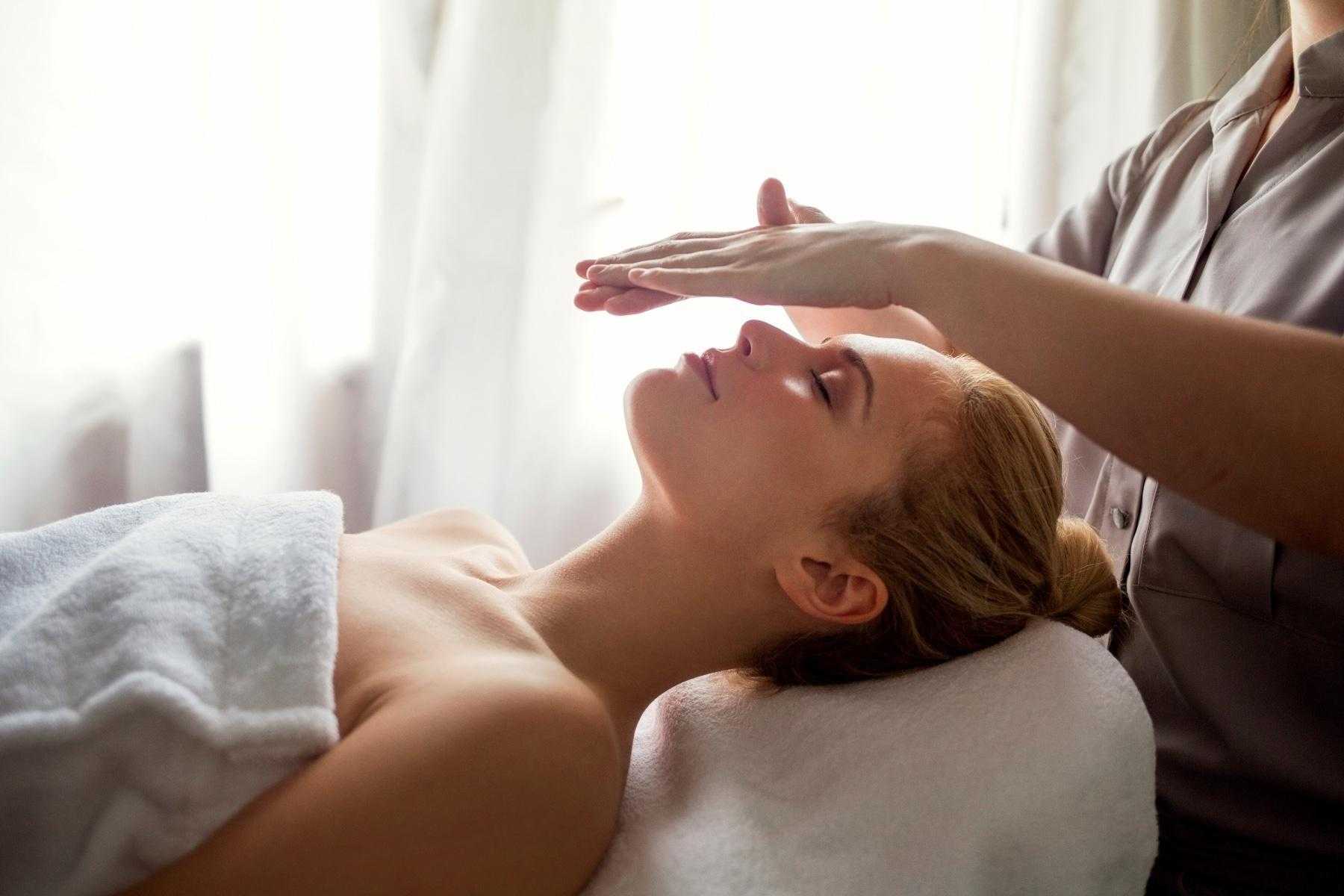 A woman receiving a Reiki treatment.