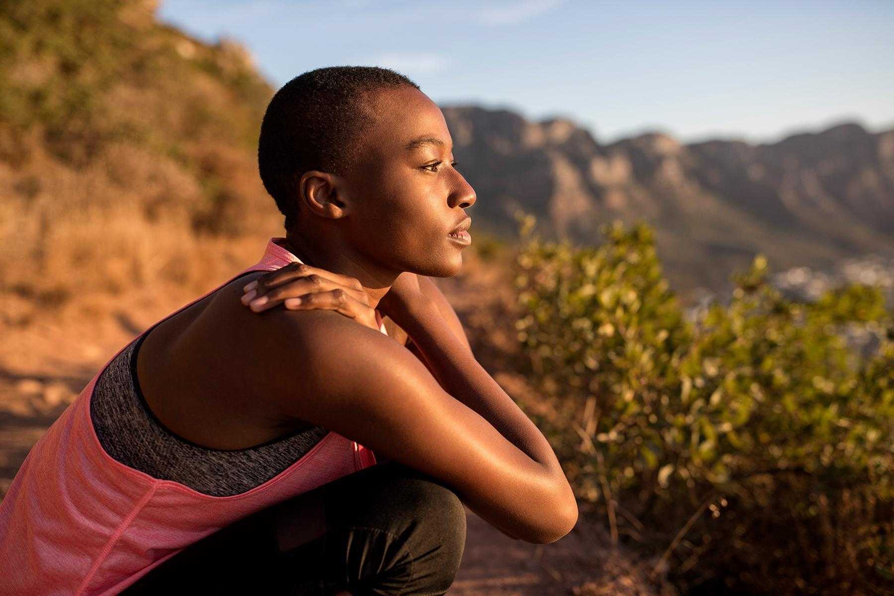 A woman on a hike taking a moment to take in the scenery.
