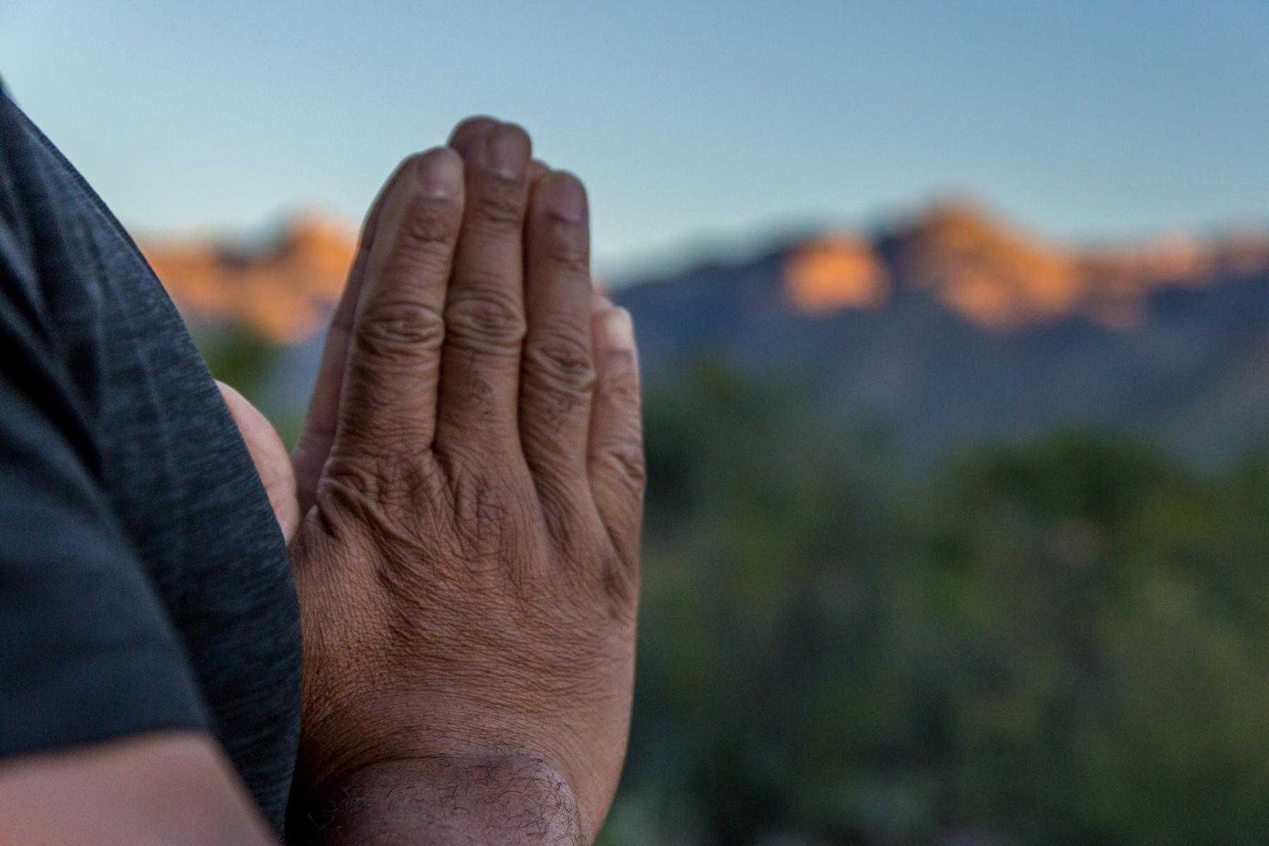 A closeup of a mature man's hands in prayer.
