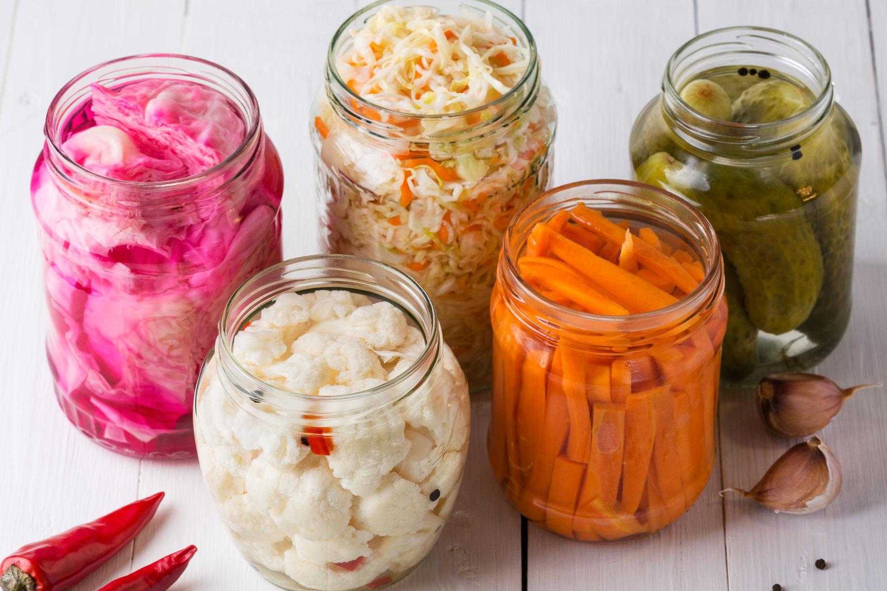 Multiple jars containing various fermented foods.