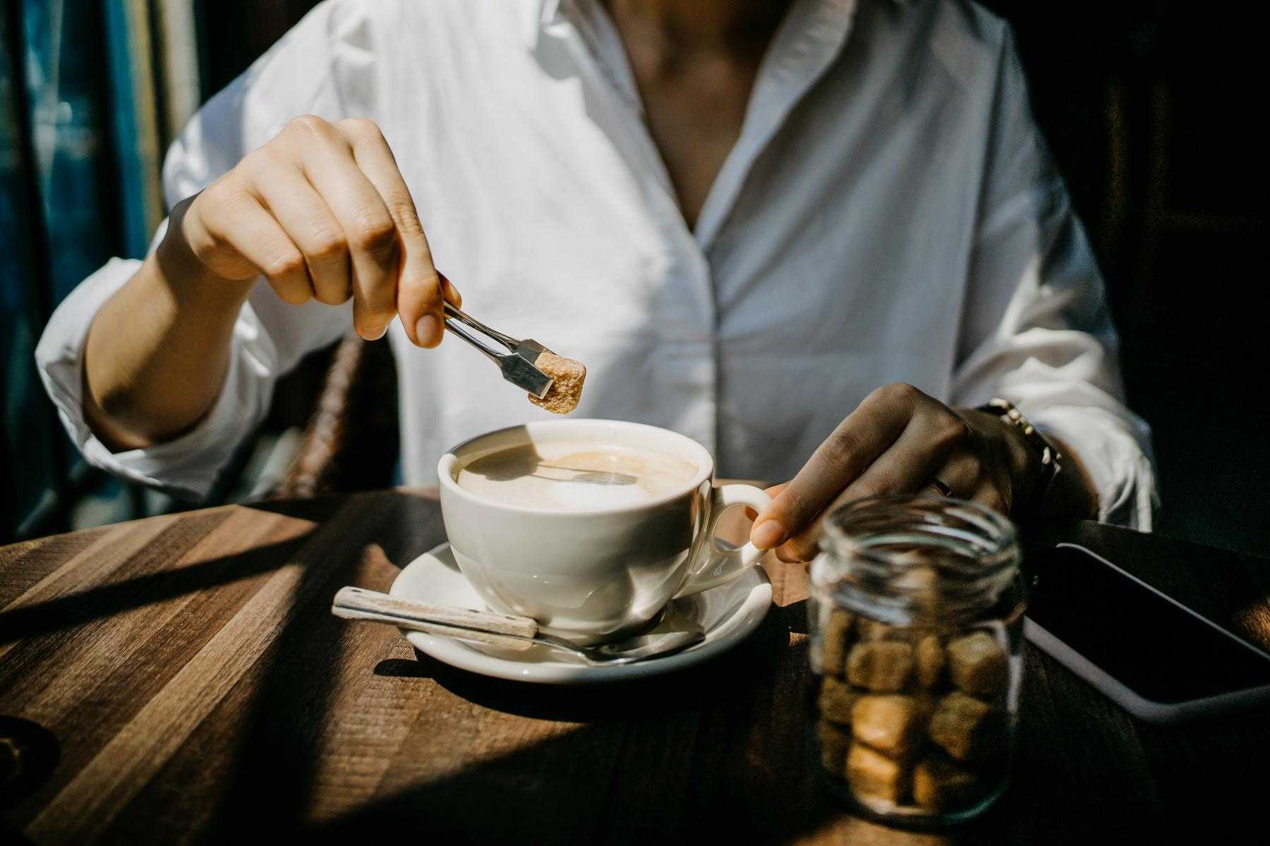 woman dropping star cube into coffee