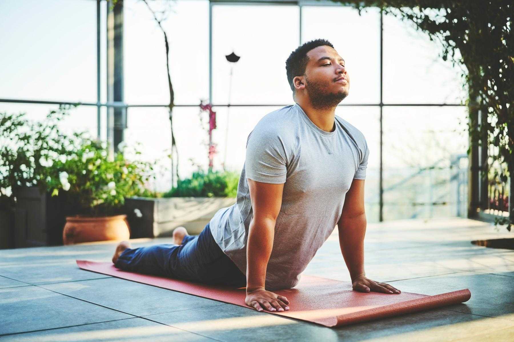 Man on yoga mat in sphinx pose.