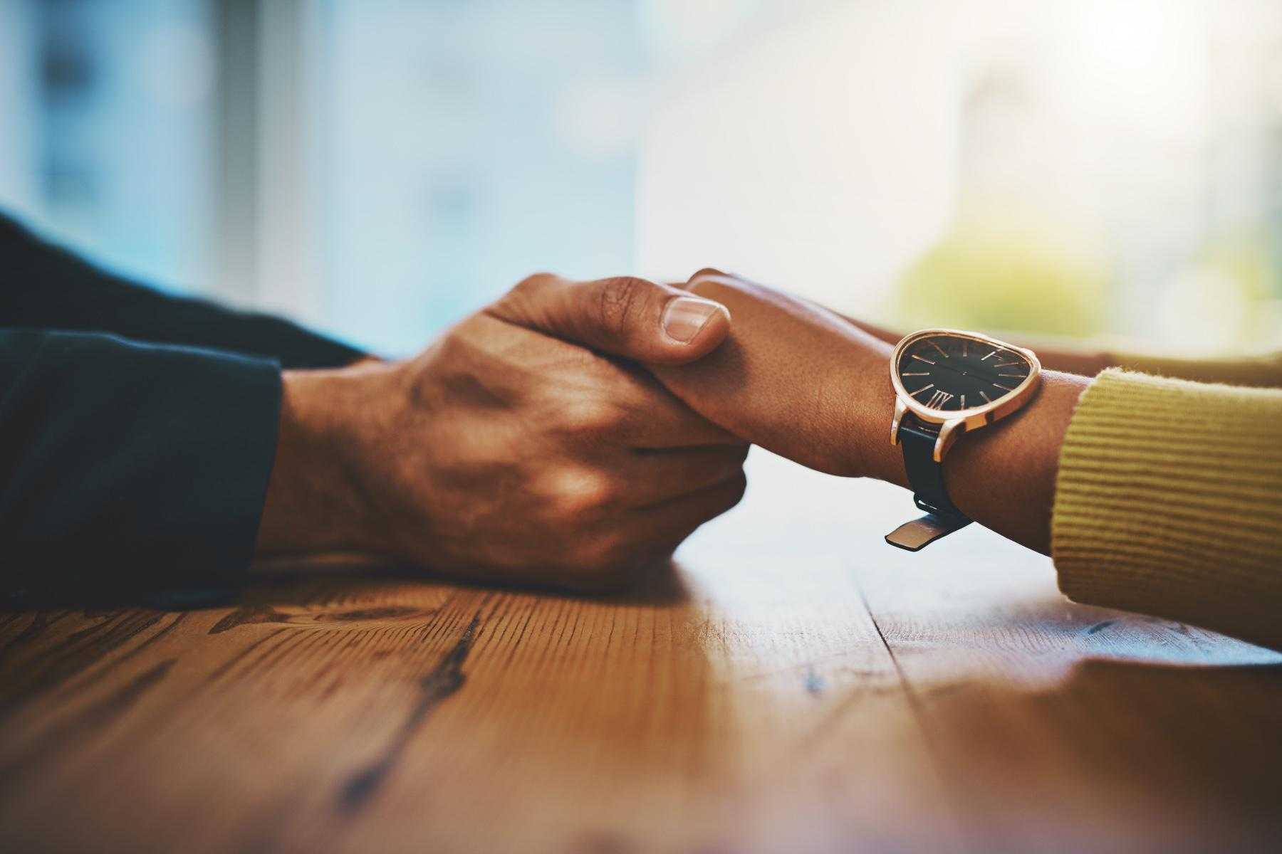 Close up of young couple hold hands.