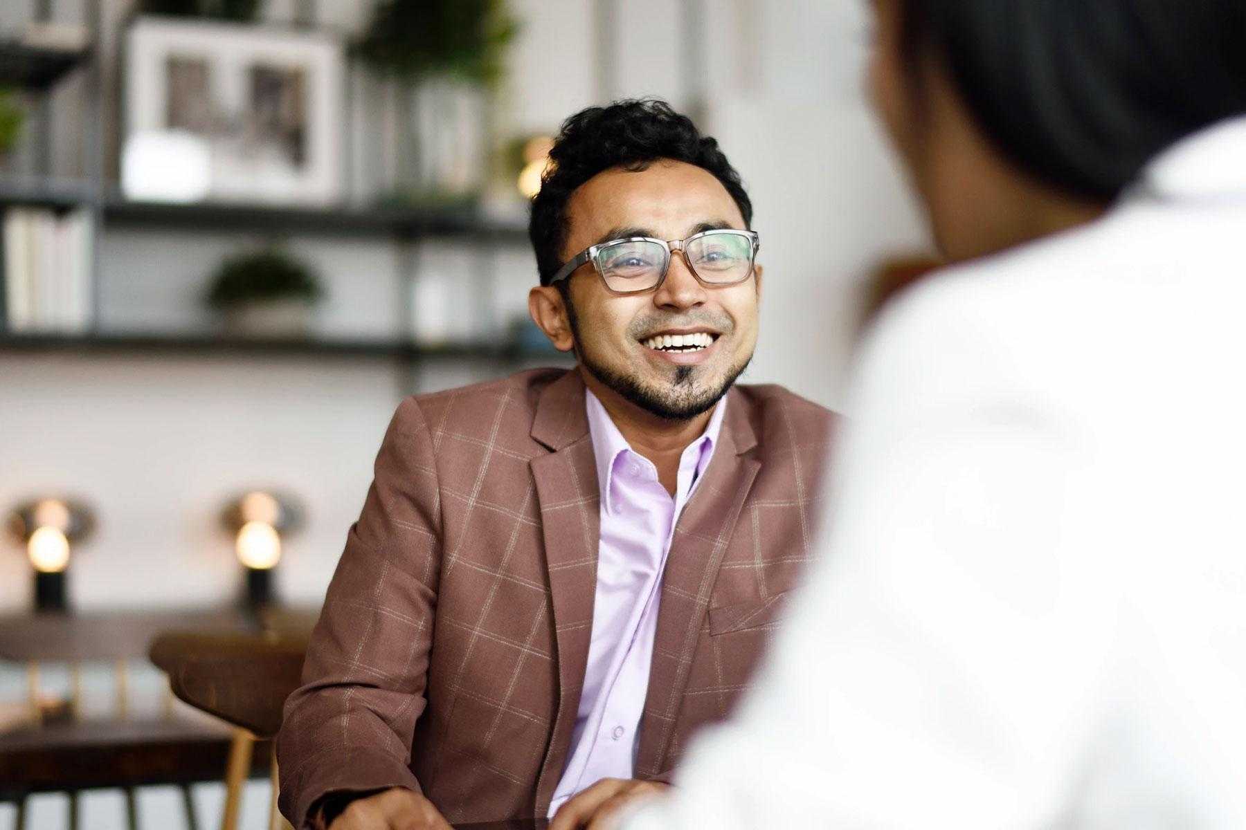 Man smiling while having a conversation.