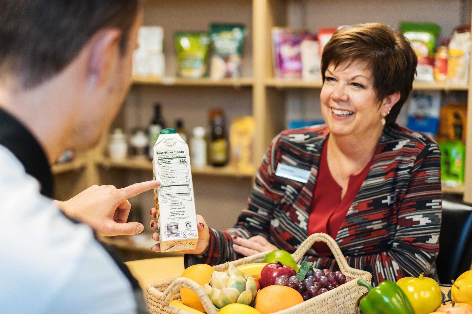 Nutritionist talking to client about box product she is holding.
