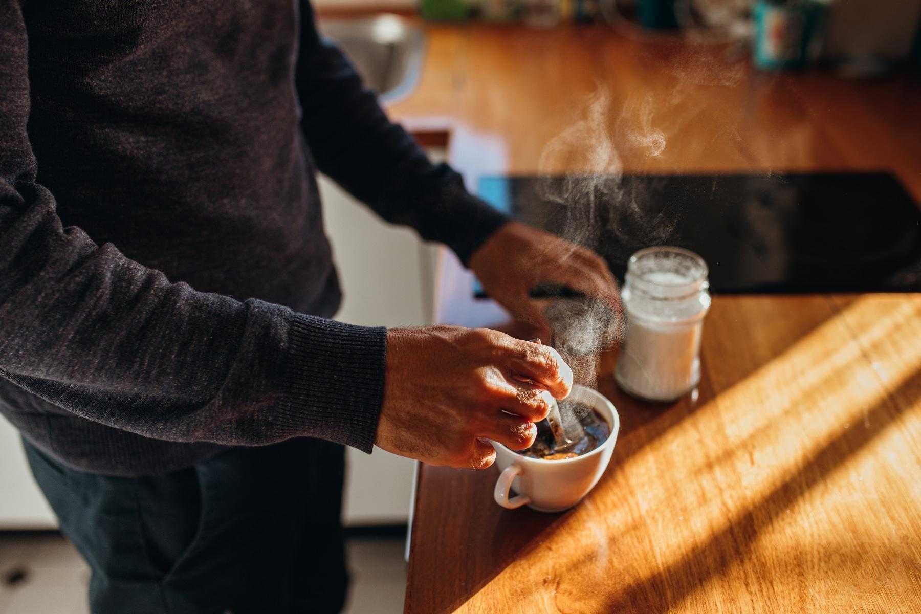 A man making a cup of tea in his kitchen.