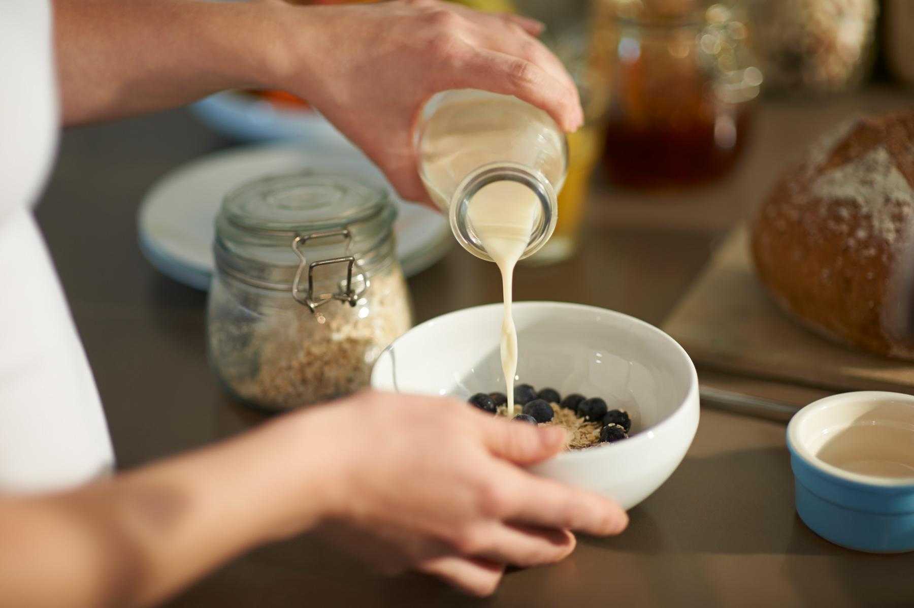 pouring milk into bowl of cereal