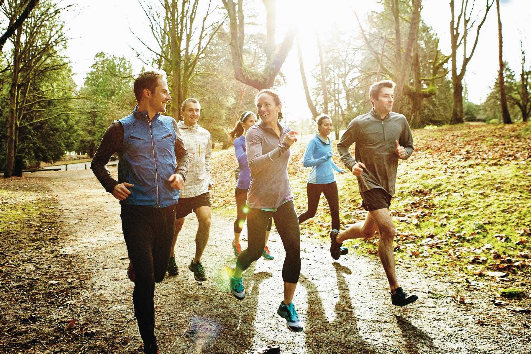 group of men and women running outside in the fall