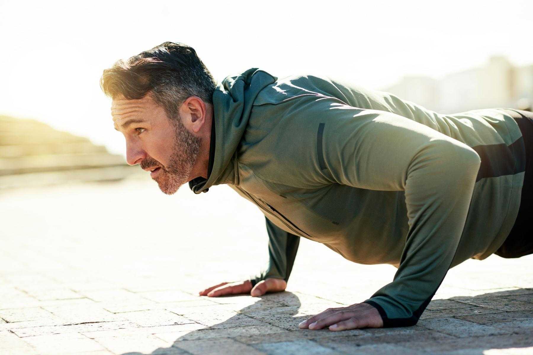 close-up of middle aged man doing a push-up from the side