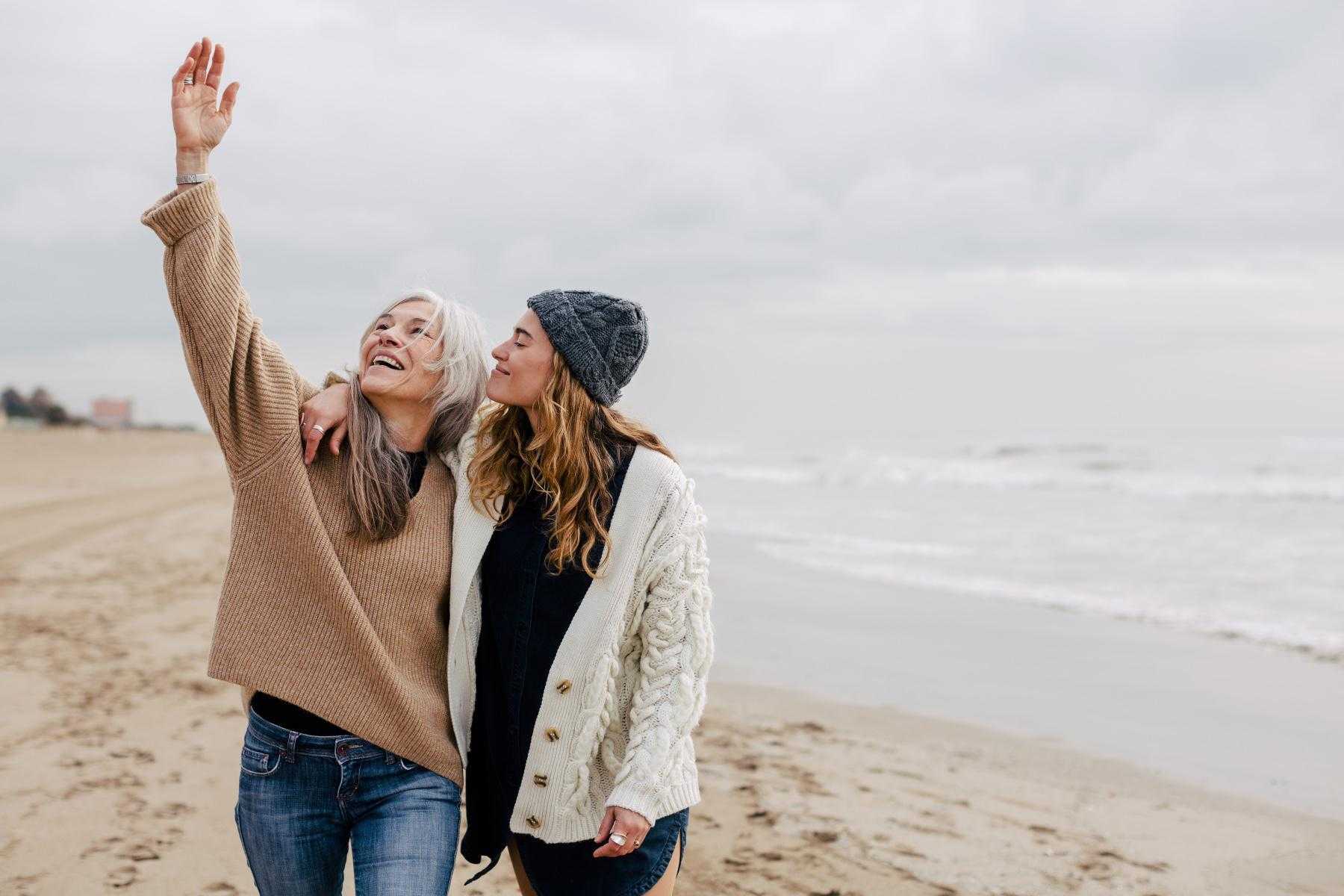 A mature mother and her adult daughter at the beach.