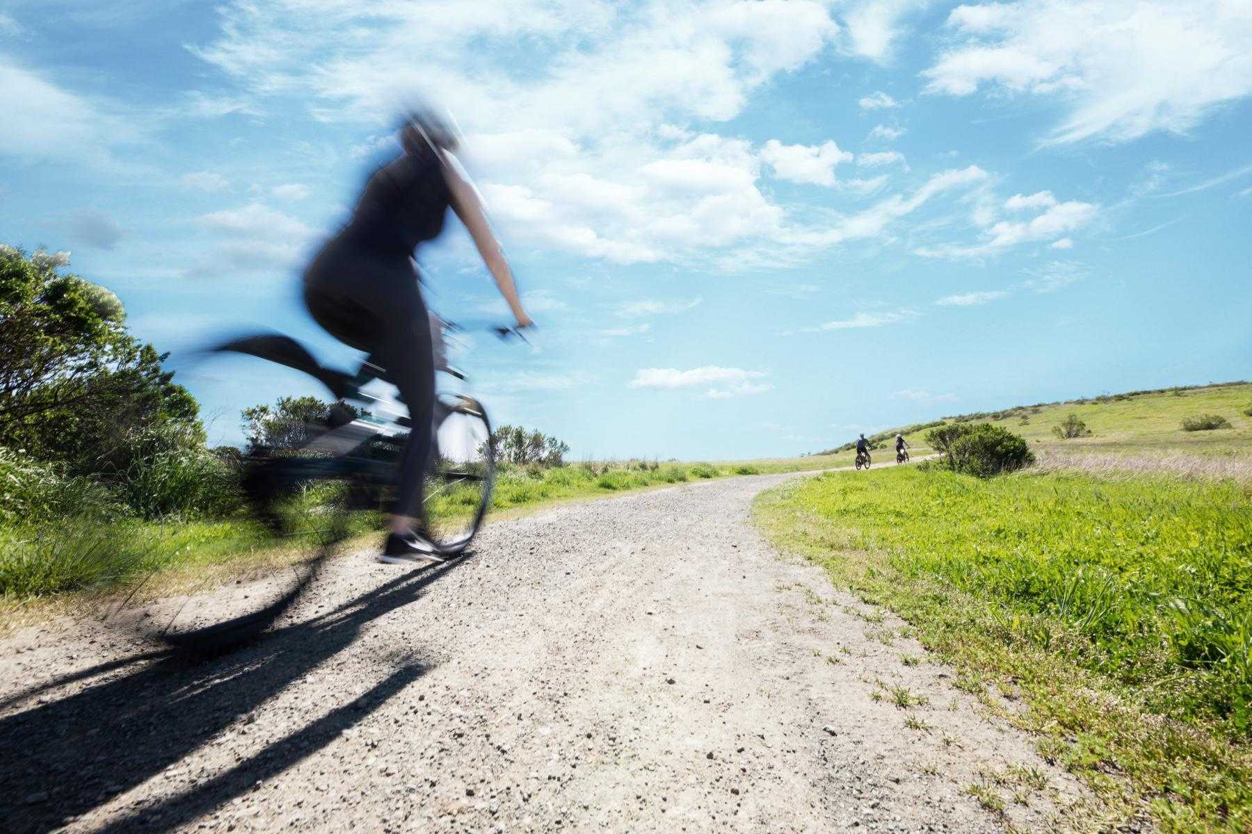 Woman bicycling outside.