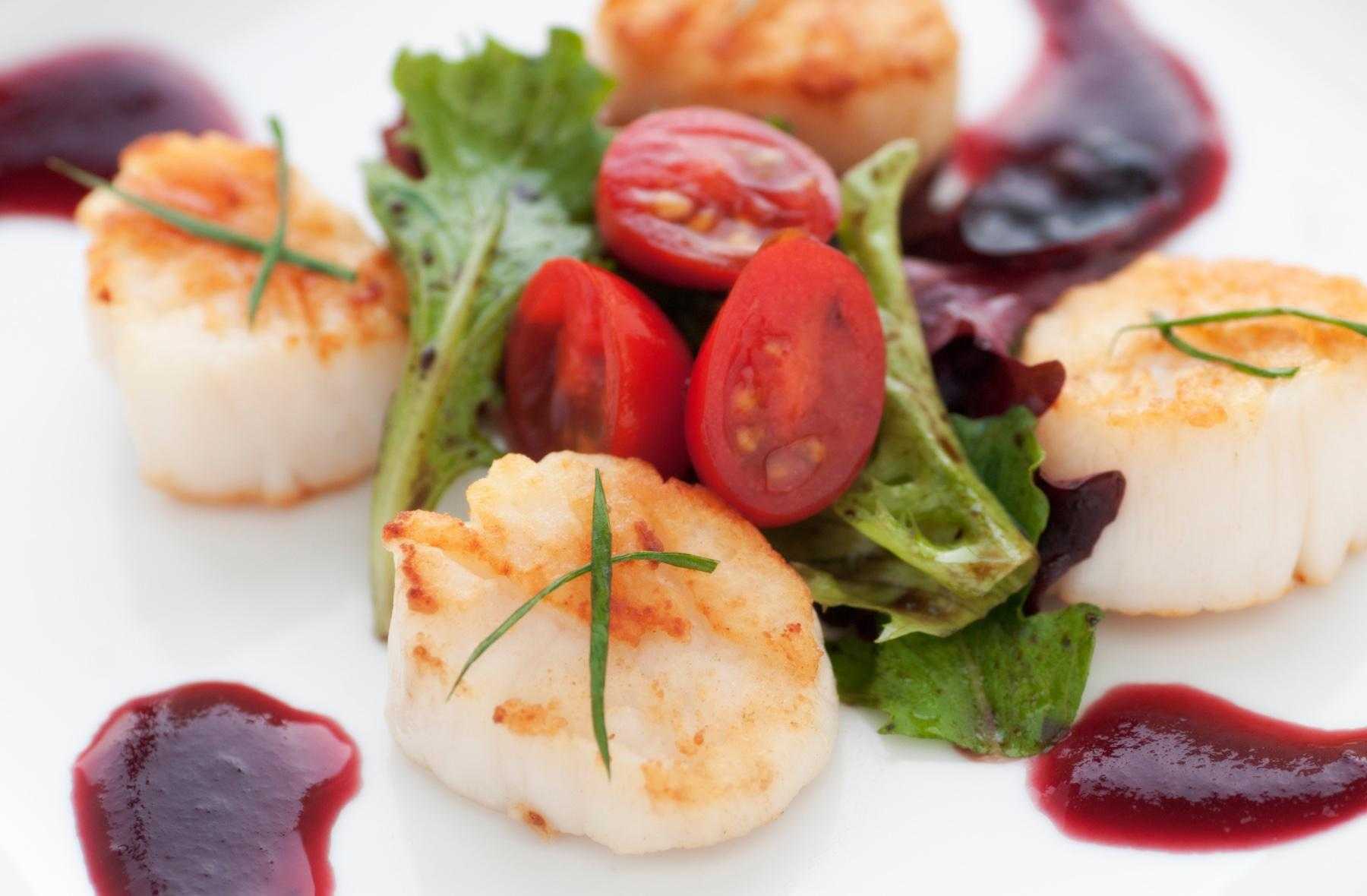 Close-up of seared scallops with cranberry vinaigrette.