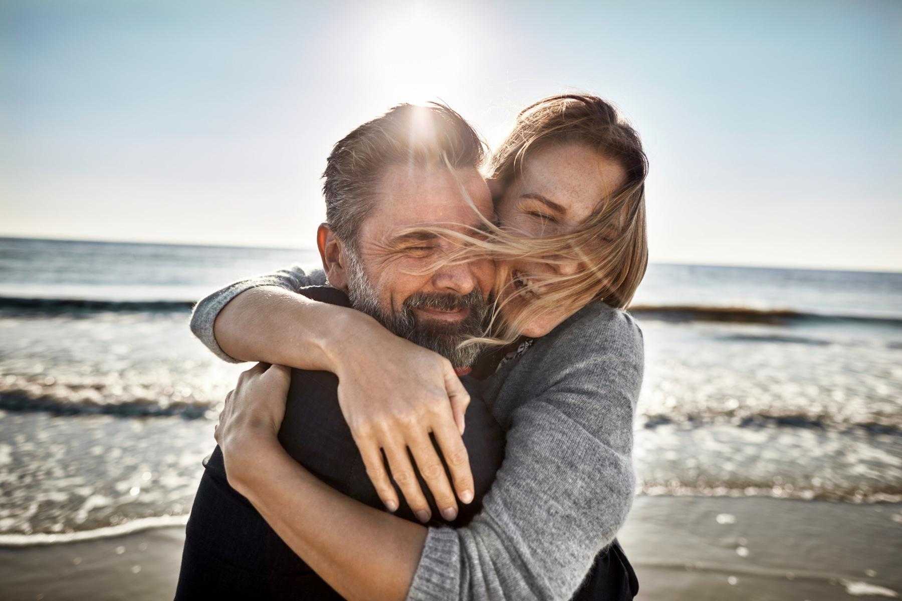 A couple embracing on a beach.