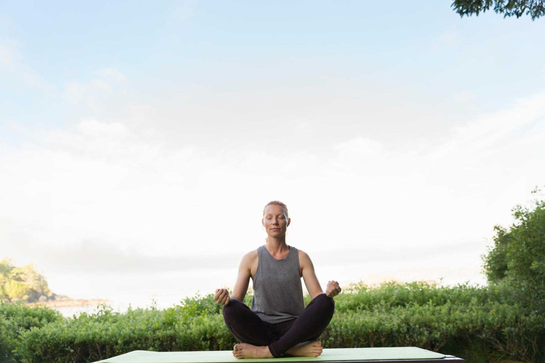 Woman meditating in a park.