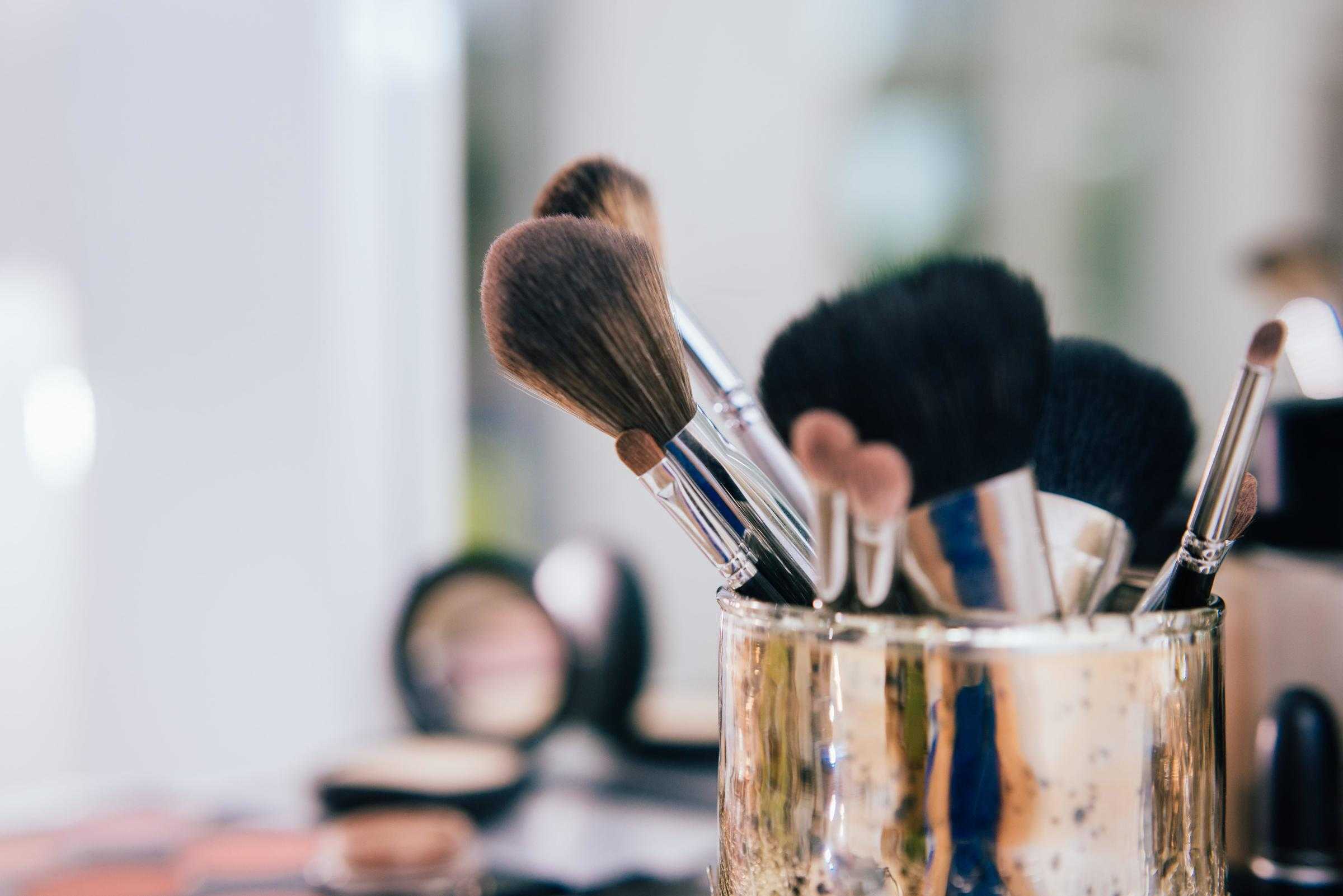 A gold container of makeup brushes.