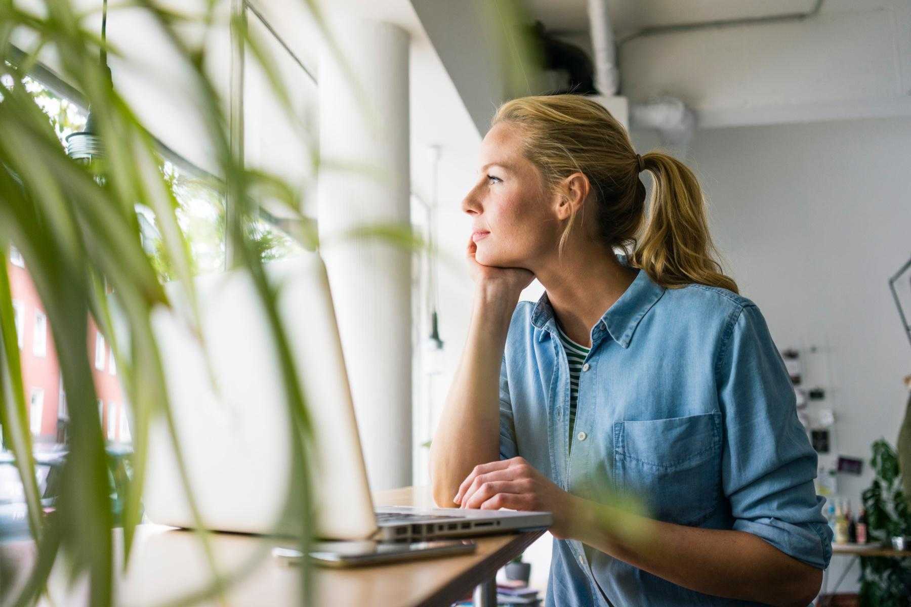 Woman looking outside her office window.