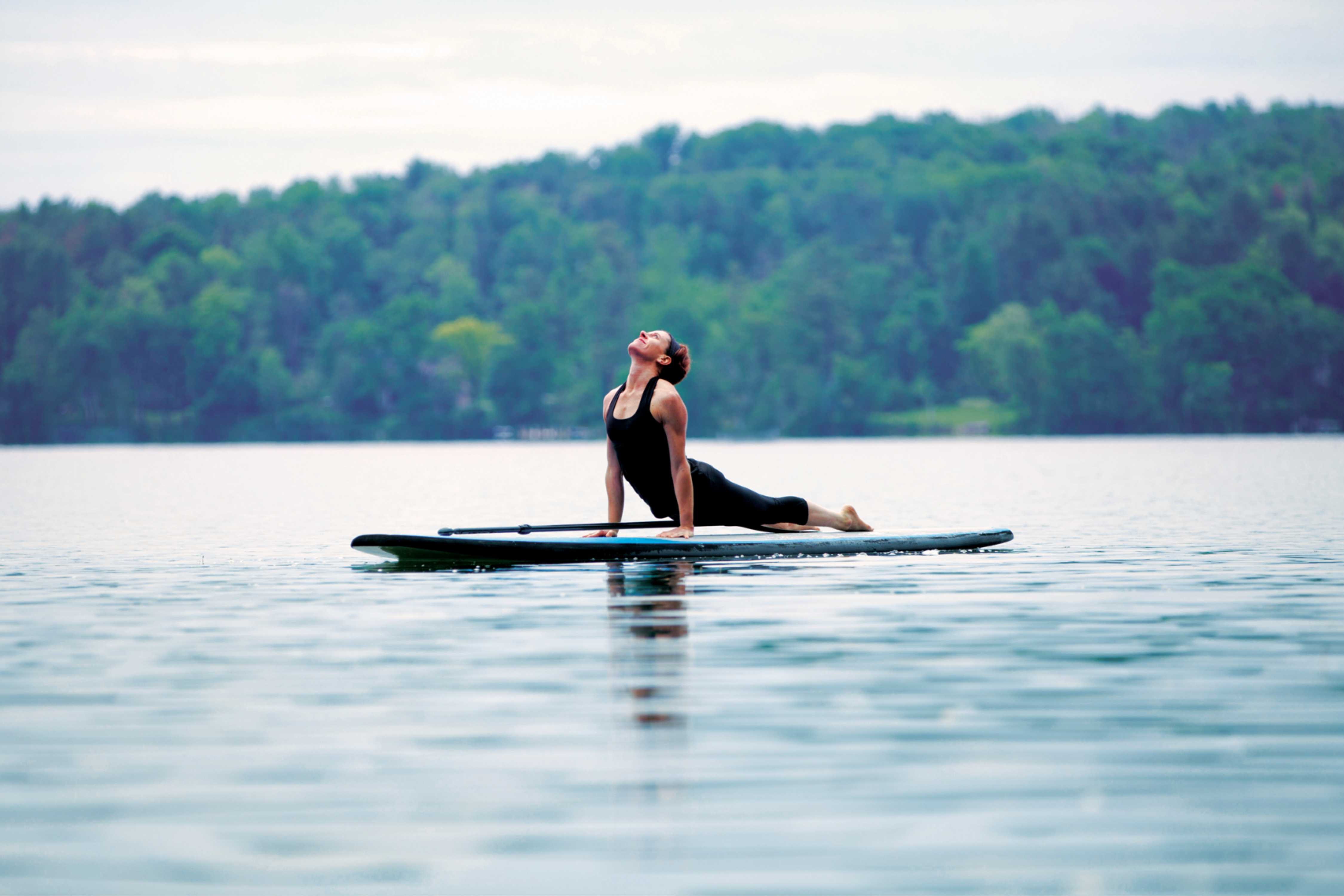 A woman doing paddleboard yoga