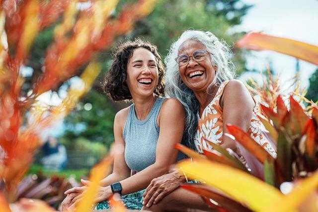 A grandmother and grandaughter smiling in the tropics