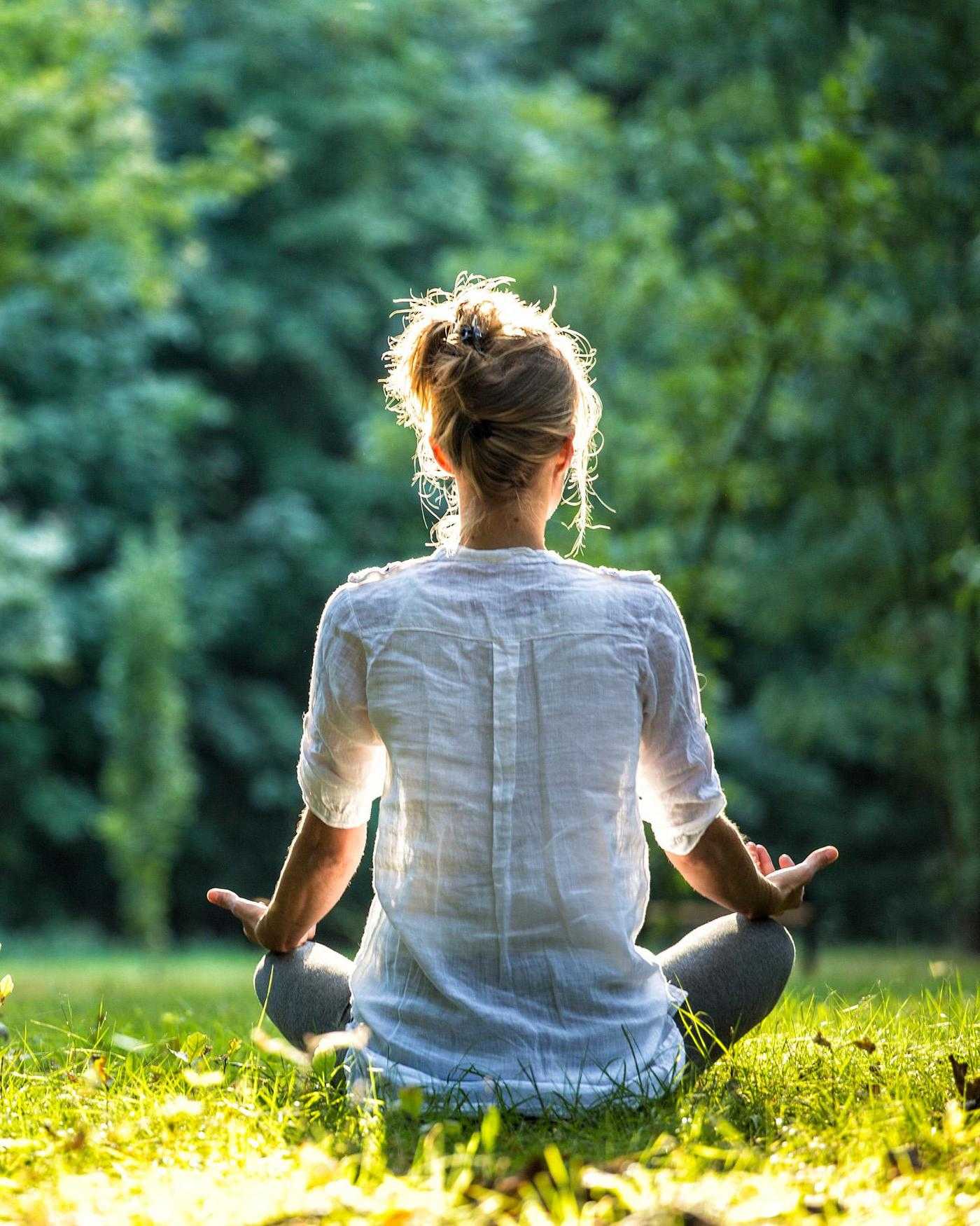 A woman meditating outdoors