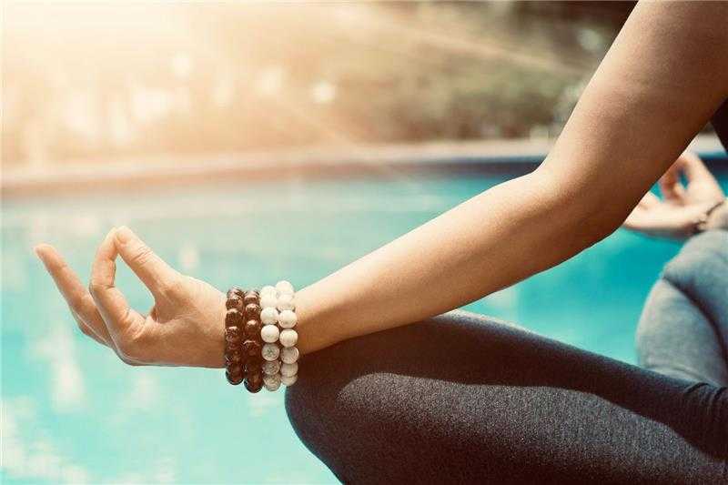 a woman meditating by the pool