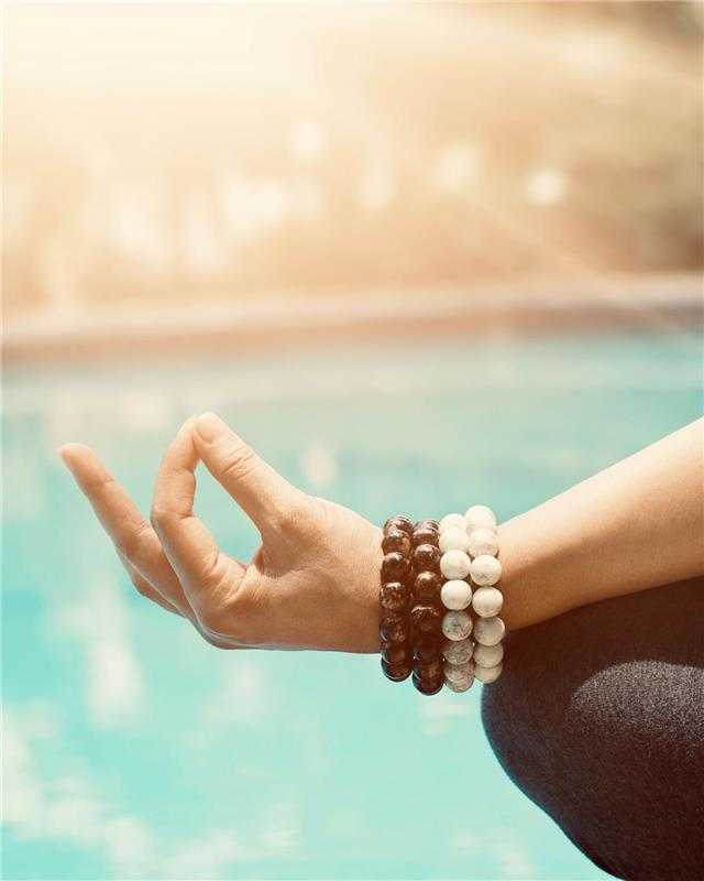 a woman meditating by the pool
