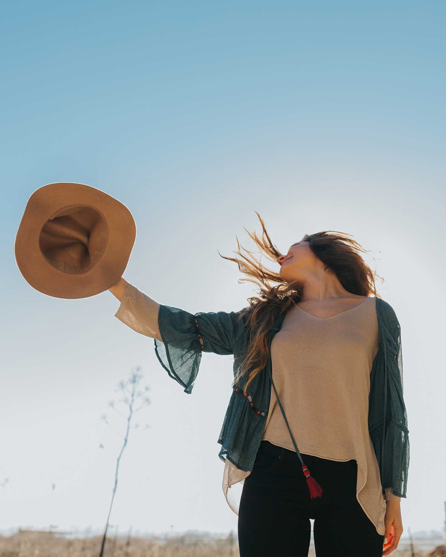 a girl throwing a cowboy hat