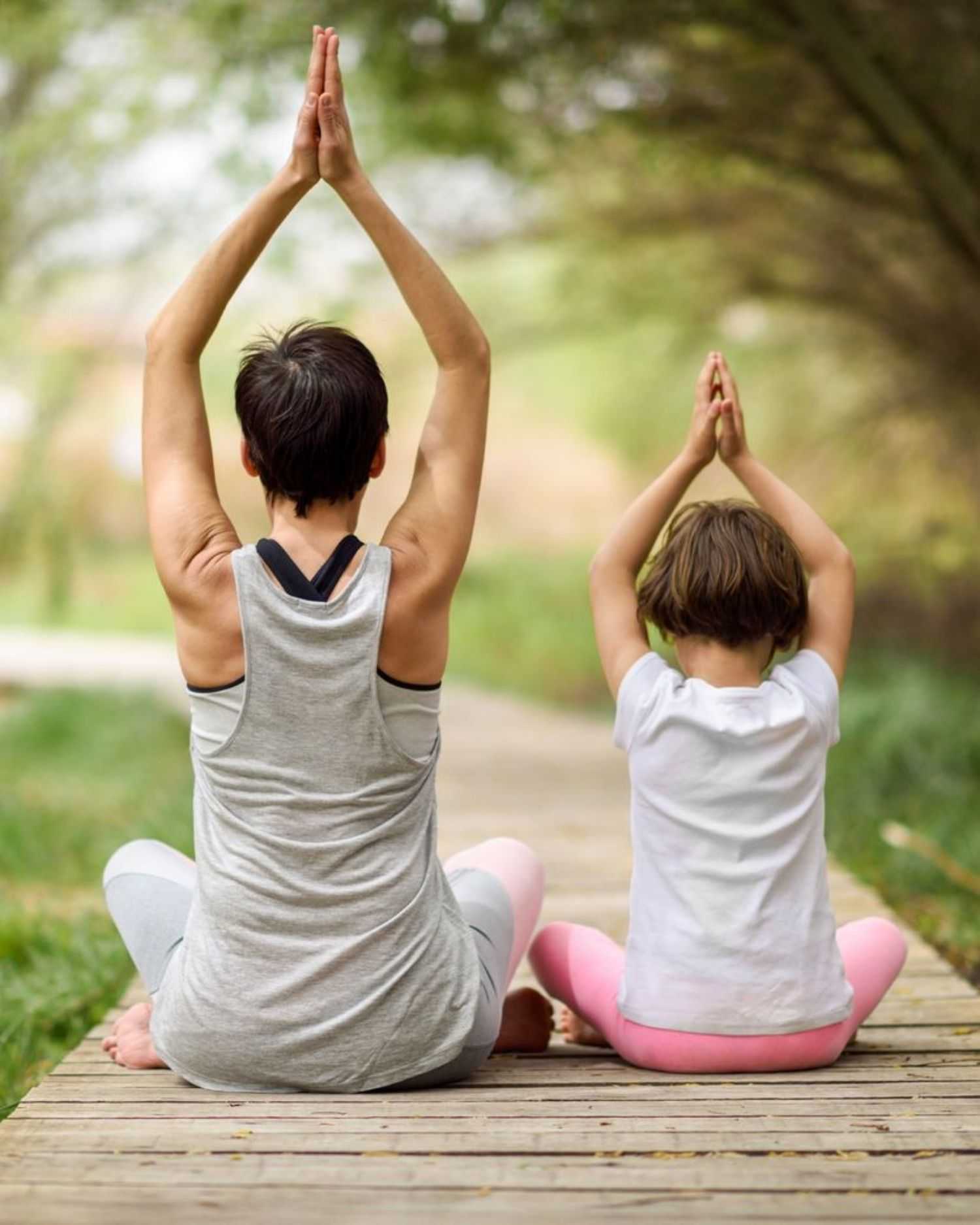 a mom and daughter doing yoga together