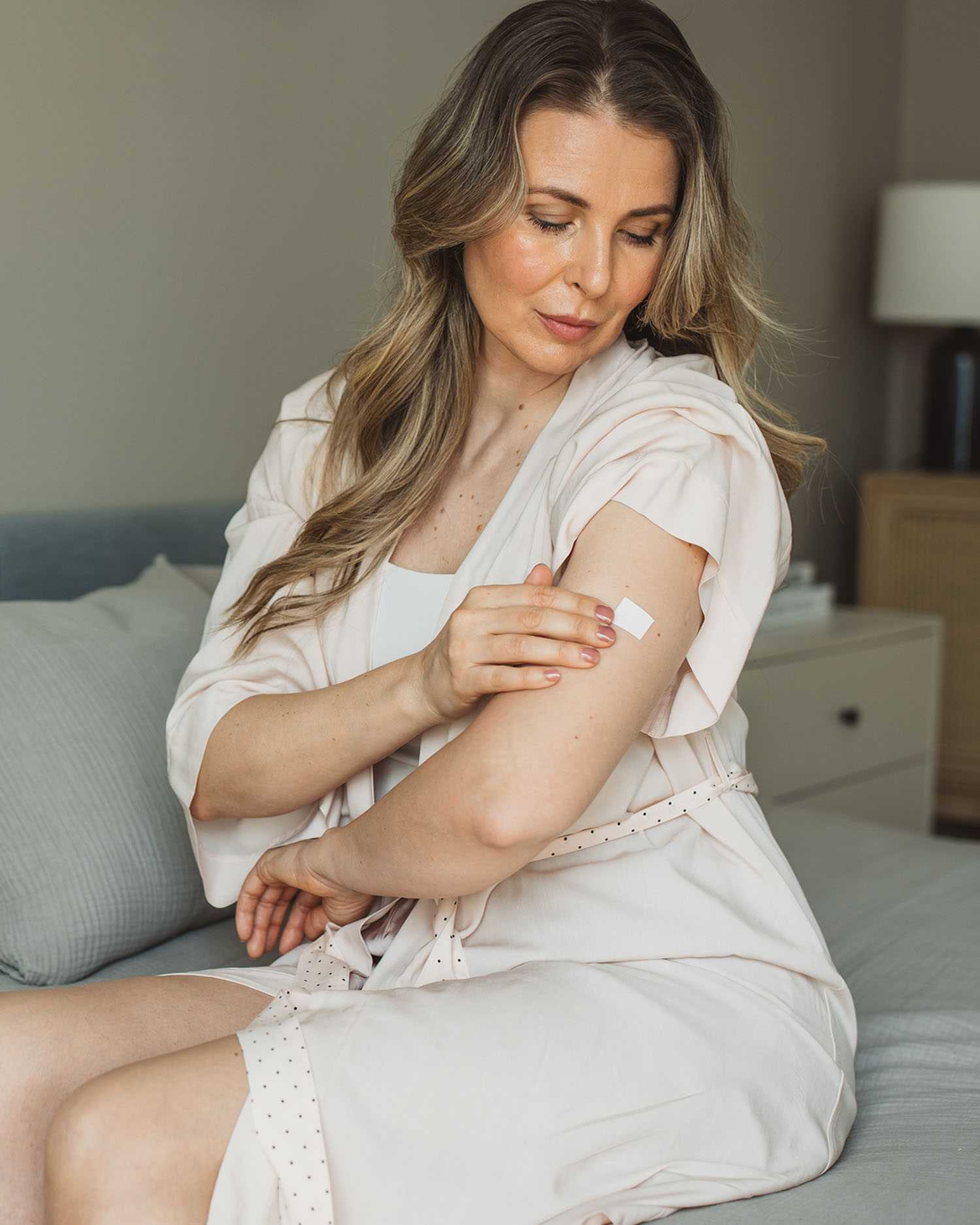 a woman applying a sticker on her leg