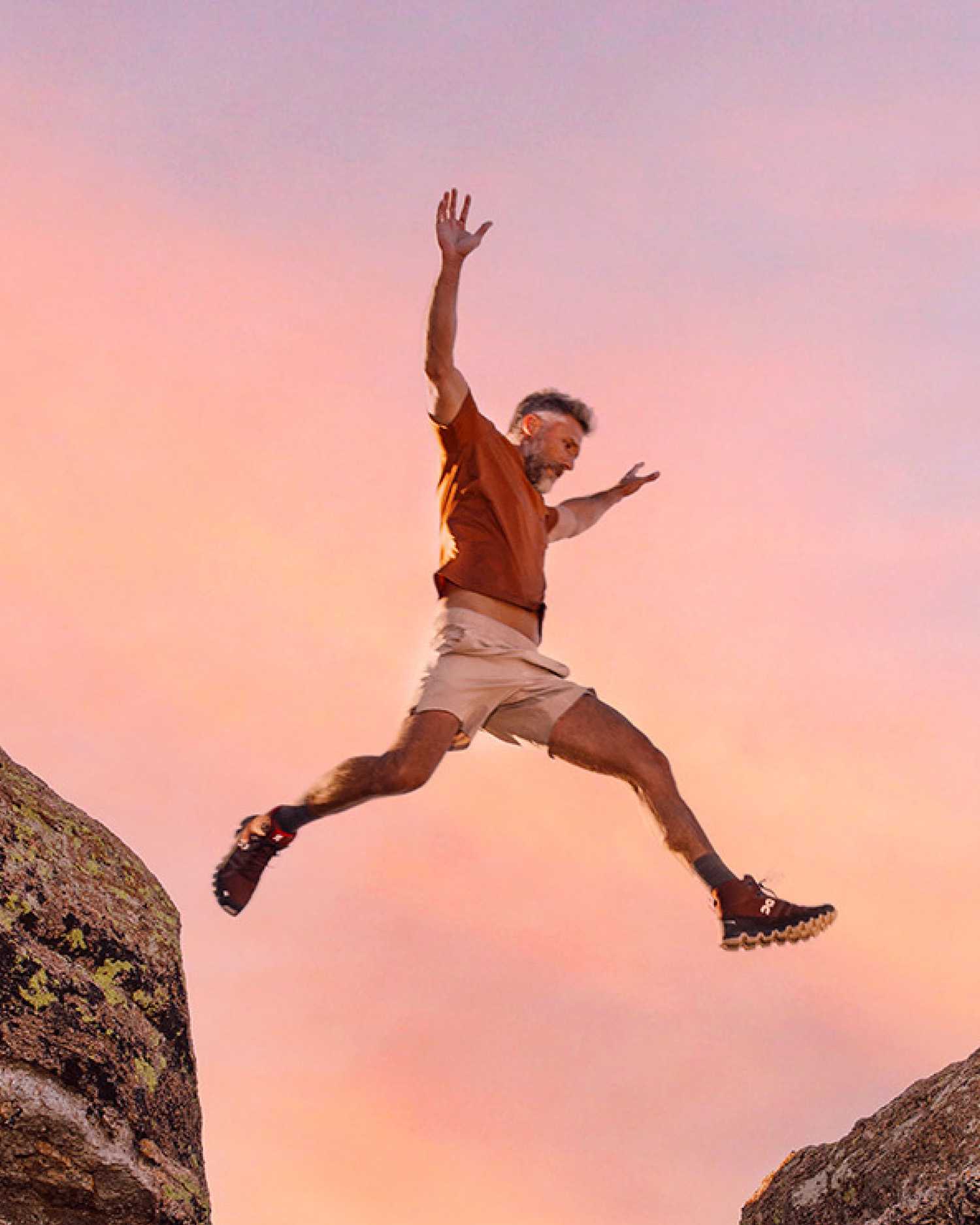 a man jumping over a rock