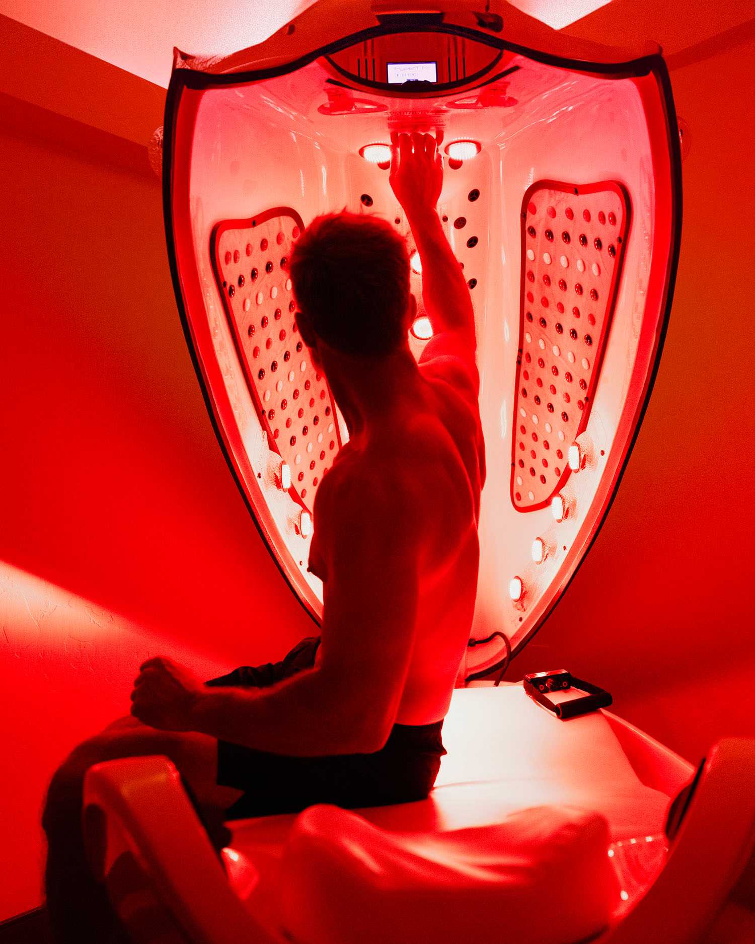 a man in a red light bed