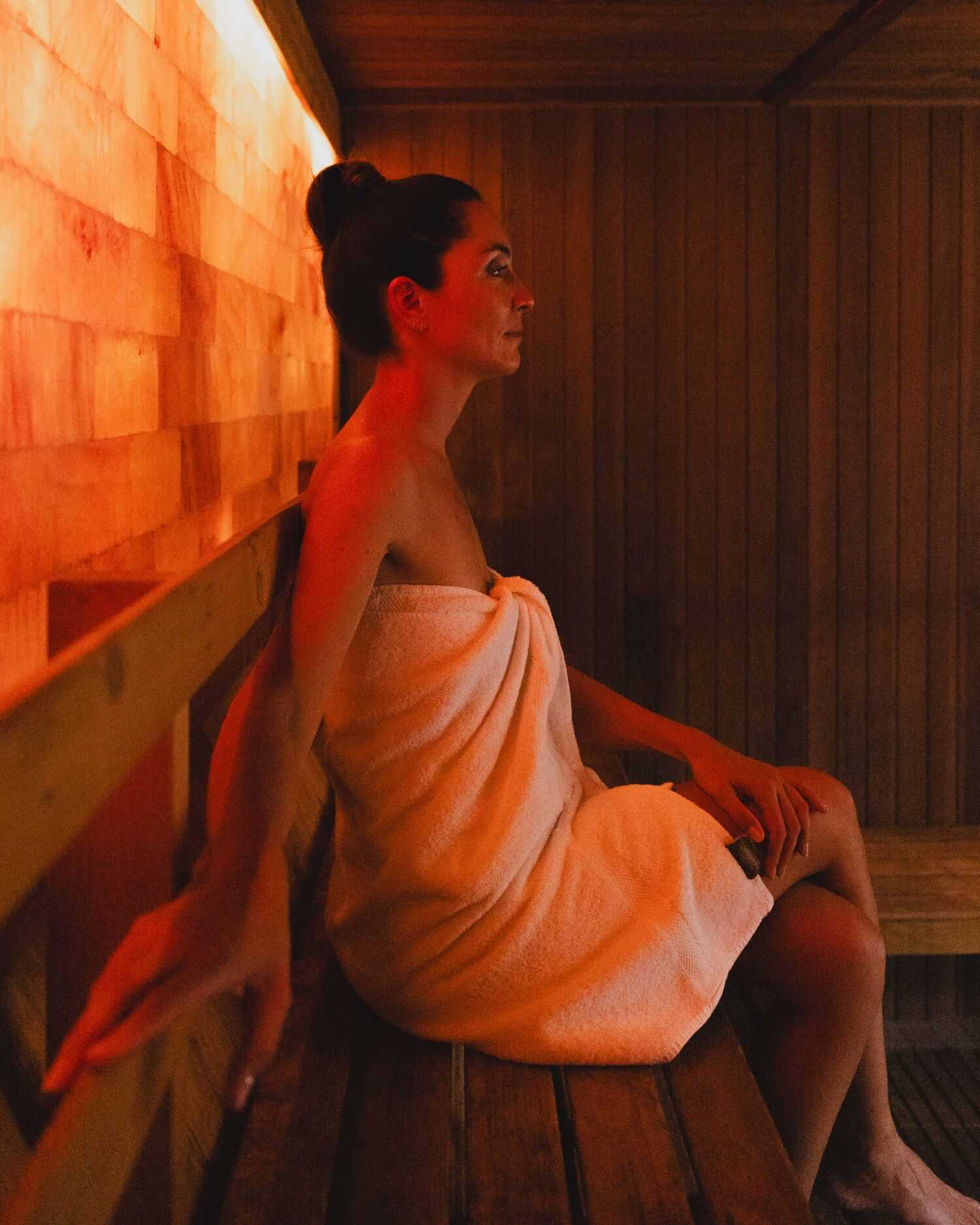 Woman in Towel in Sauna with Salt Wall