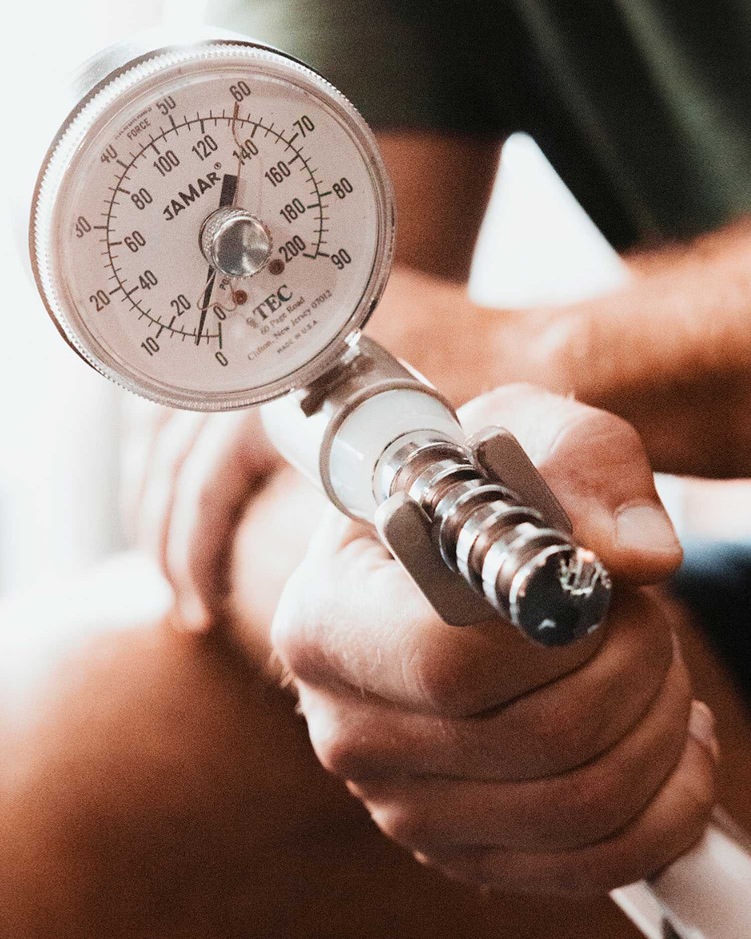 a man squeezing a grip strength tester