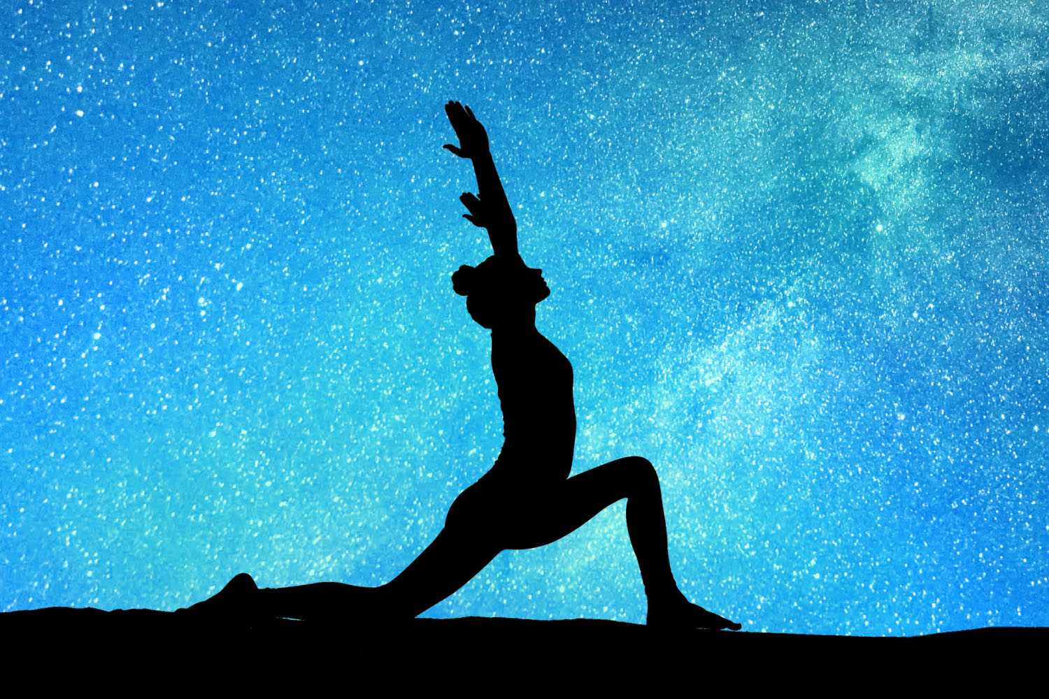 a woman doing yoga under the stars