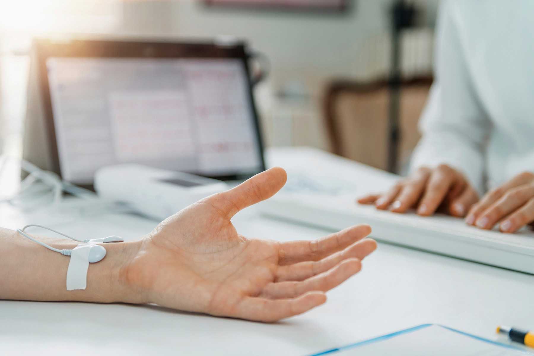 a hand hooked up to a monitor