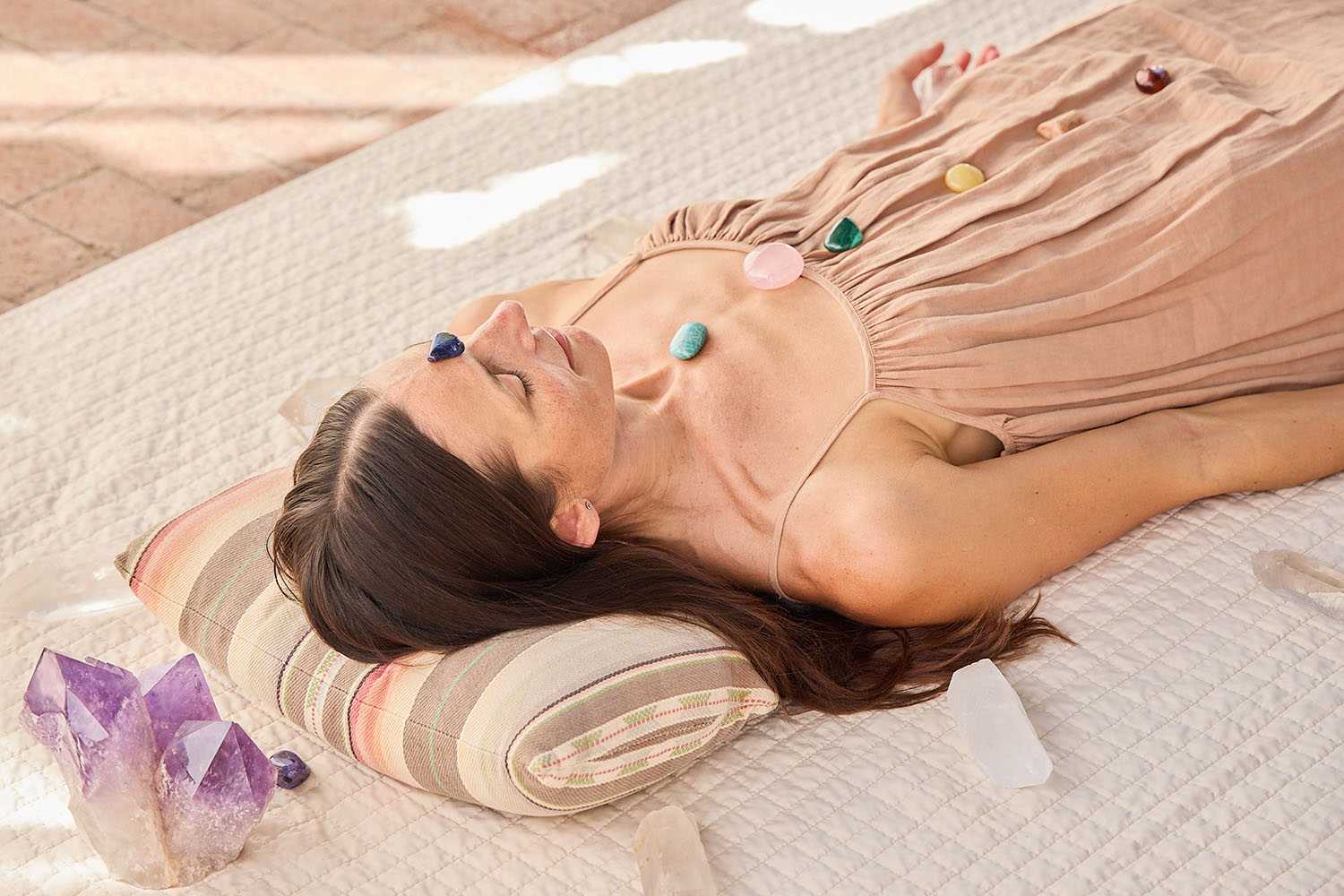 a woman meditating with crystals