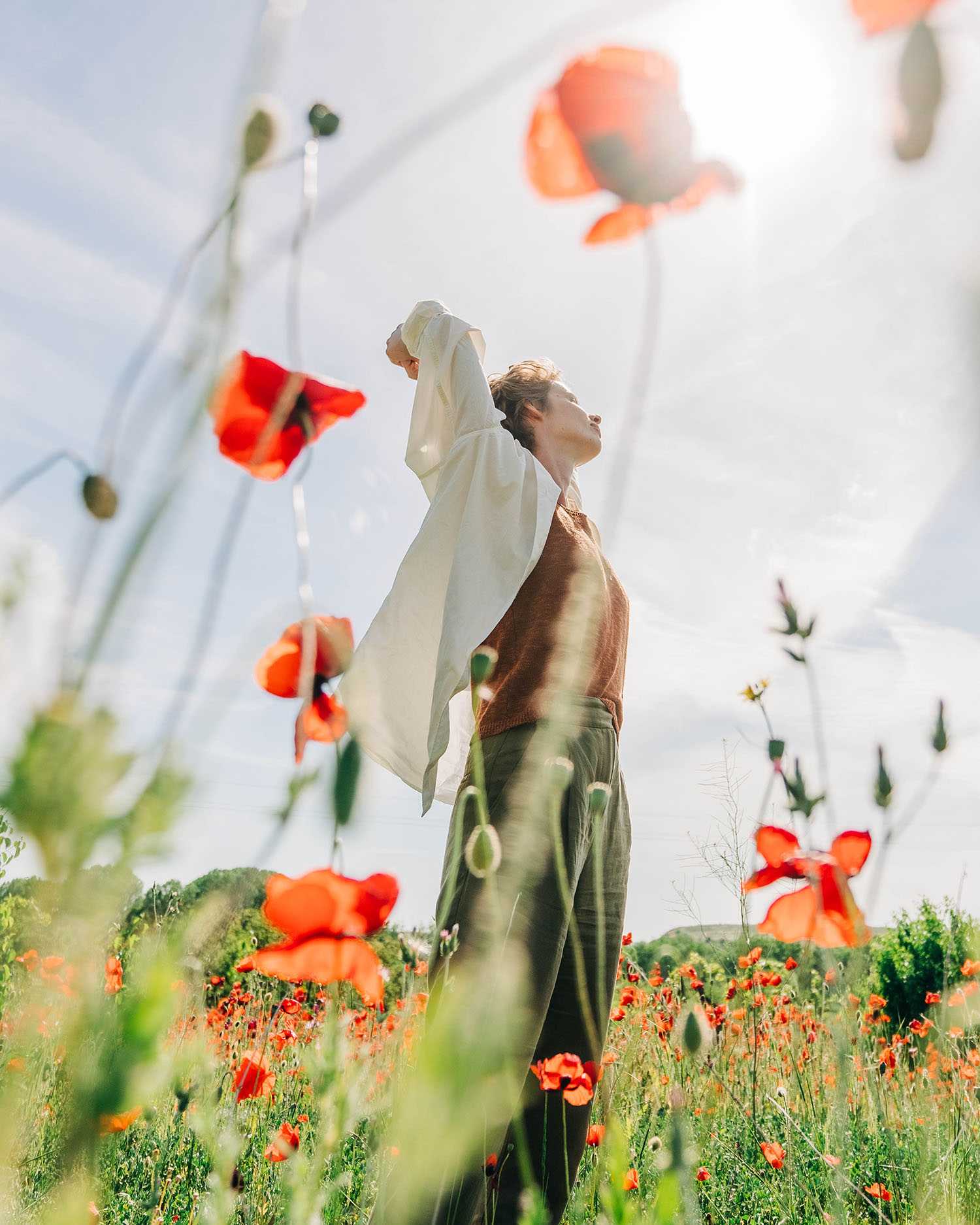 a woman standing in a field of flowers