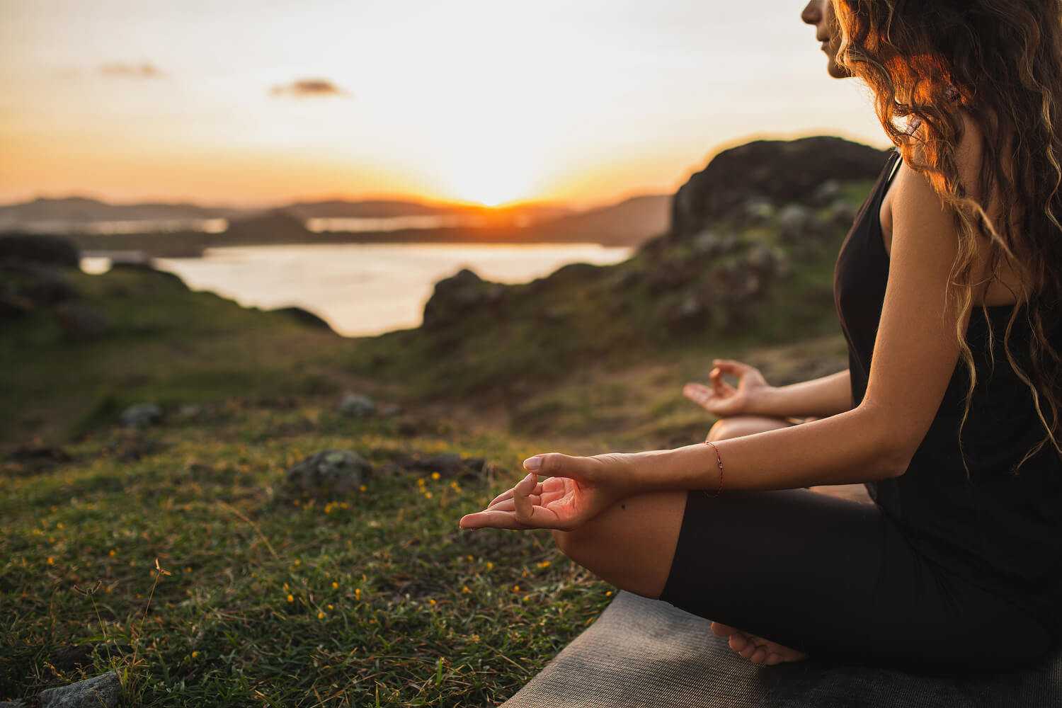 A woman meditating by a lake
