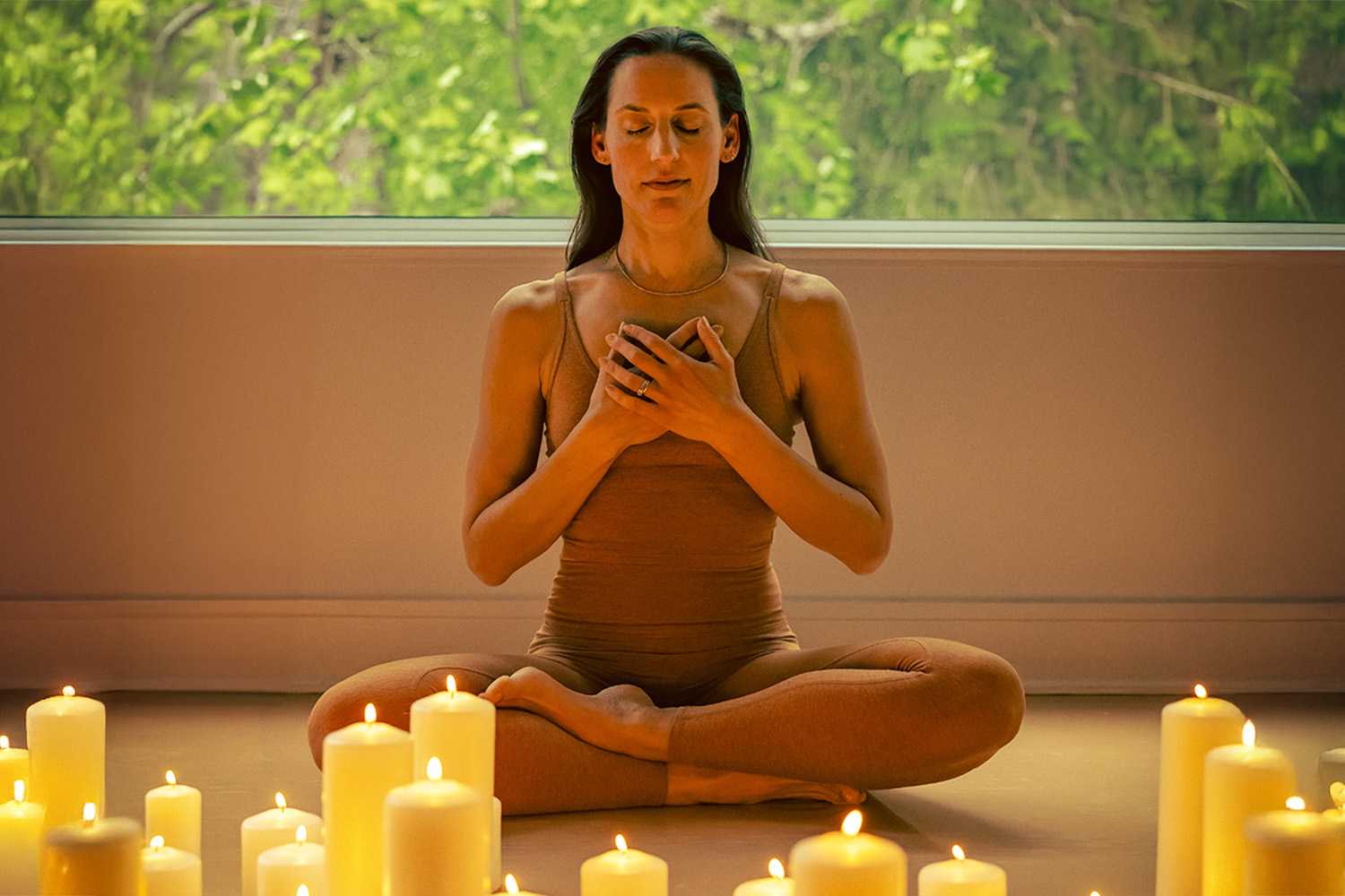 a woman meditating by candles